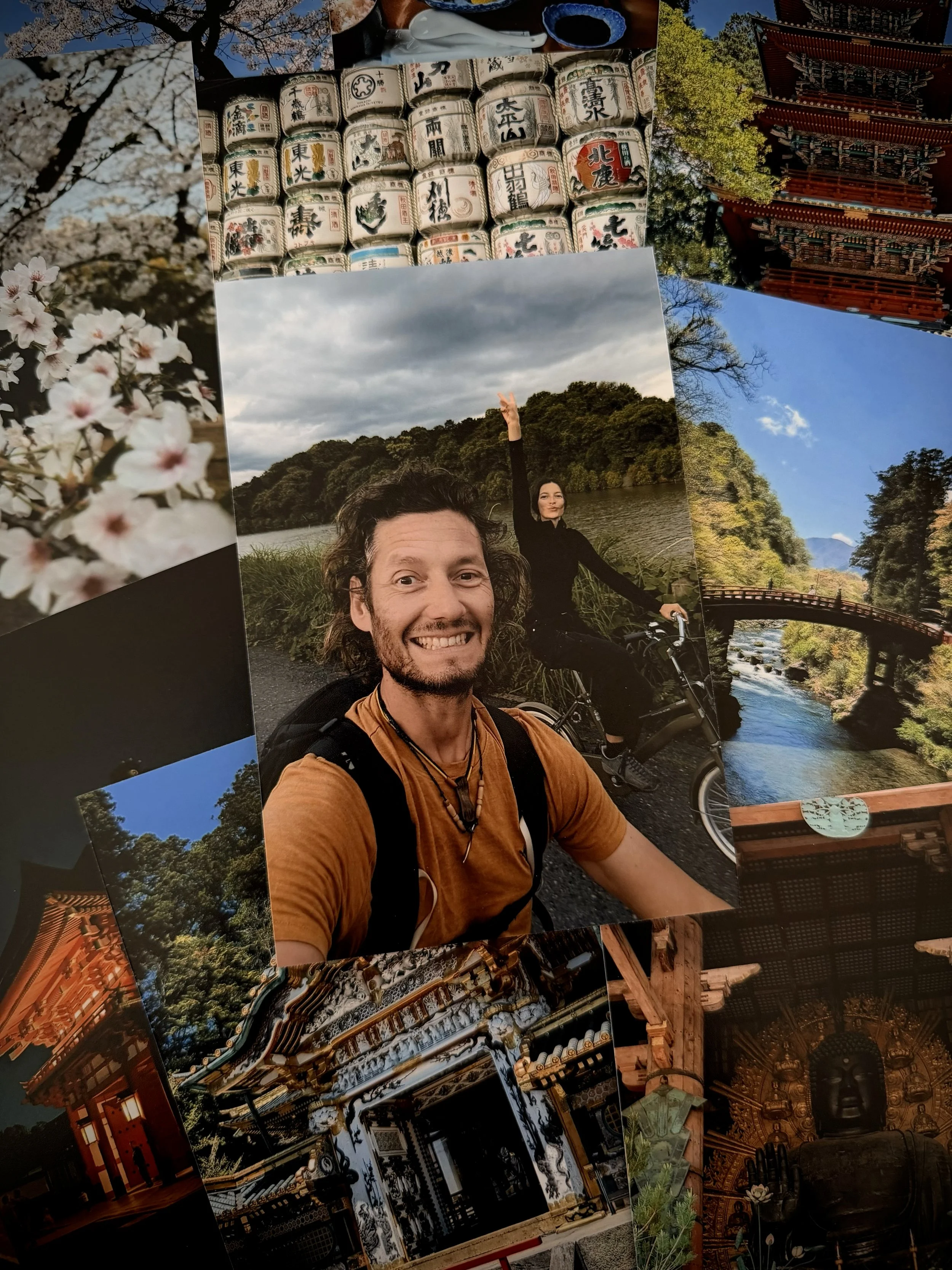 Lumica printed photos disposable camera. Photographs includes a smiling man and woman riding bicycles near a river with lush greenery, traditional Japanese temple architecture, cherry blossoms, and sake barrels, capturing scenes from Japan.