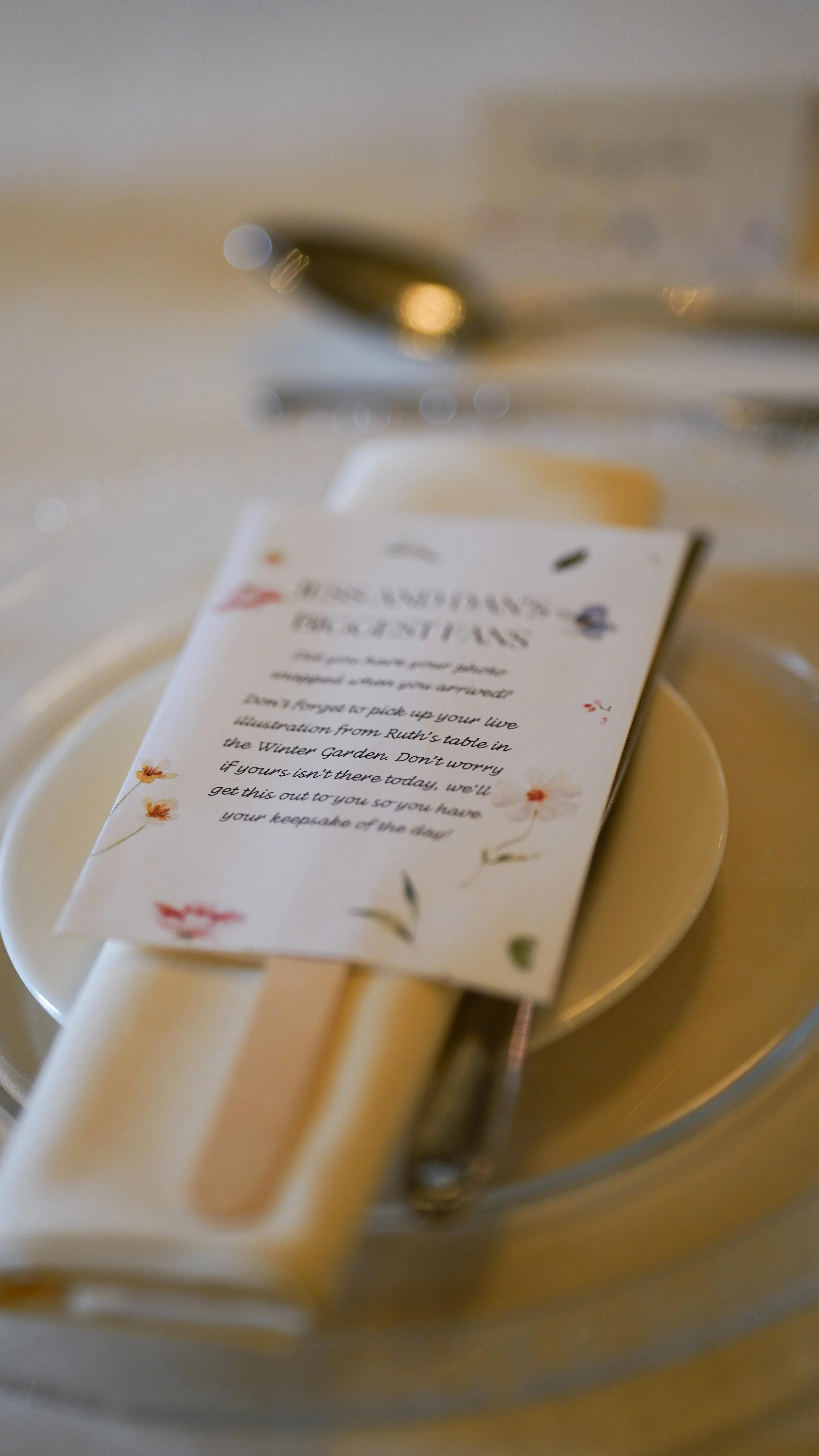 Close-up of a Place Setting with a small plate, napkin, silverware, and a menu card on top at a restaurant table.