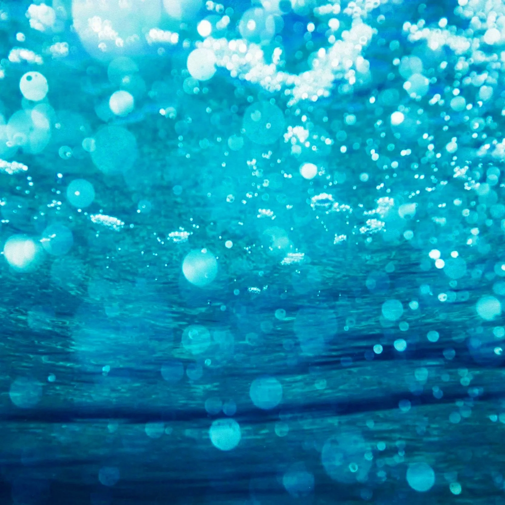 Blue abstract background with bokeh light effects and sparkling spots.