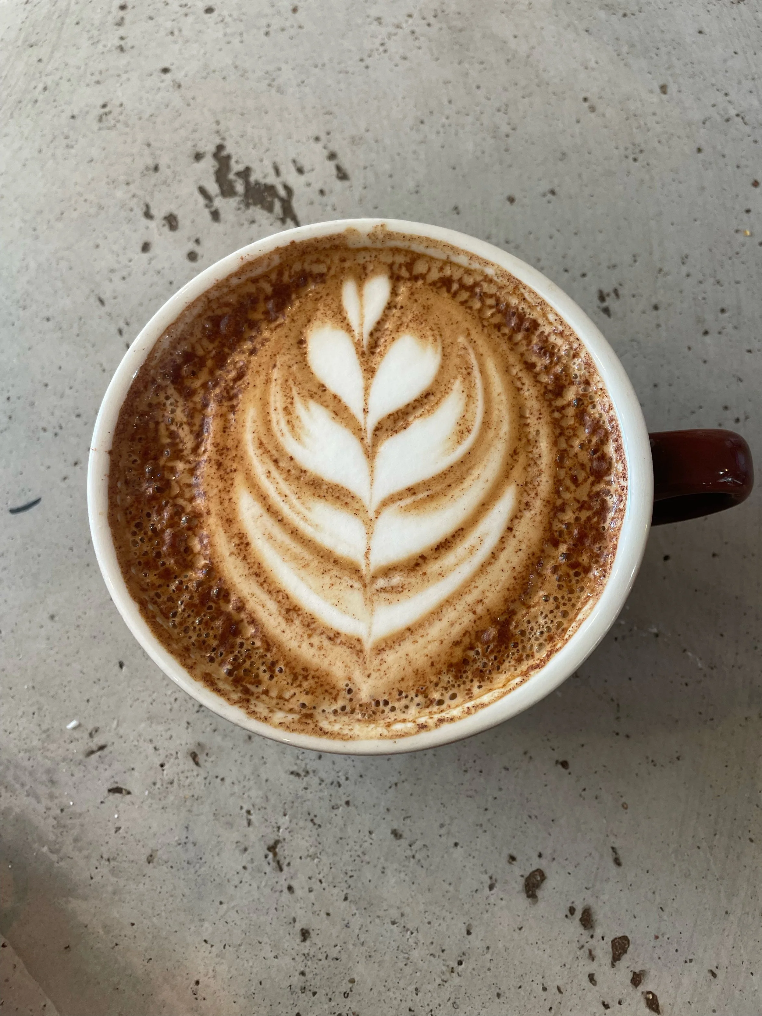 Group of people standing outside in front of a brick building, smiling for a photo.