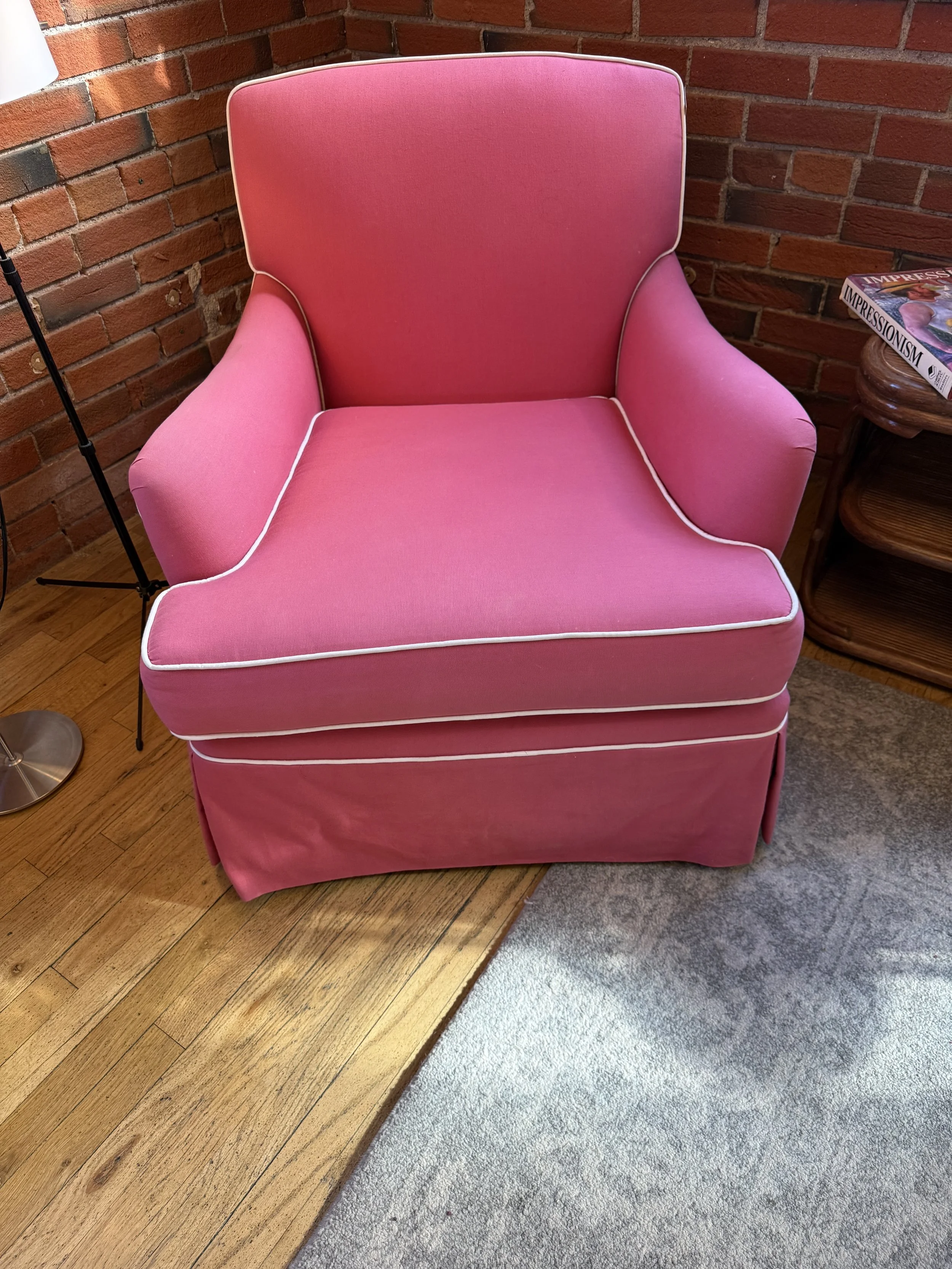 Comfy club chair upholstered in pink cotton with white piping 