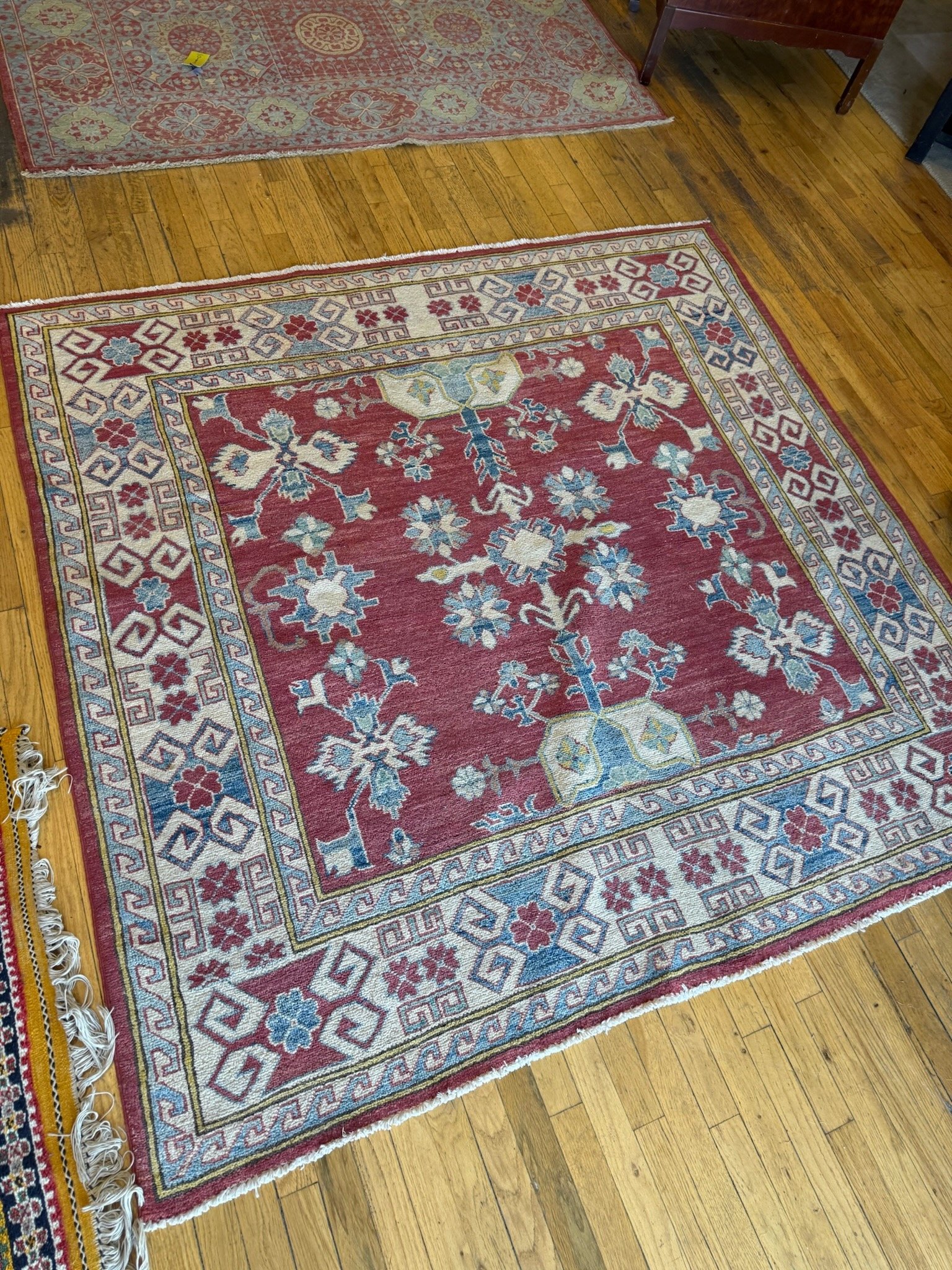 Patterned area rug with a red background and floral designs