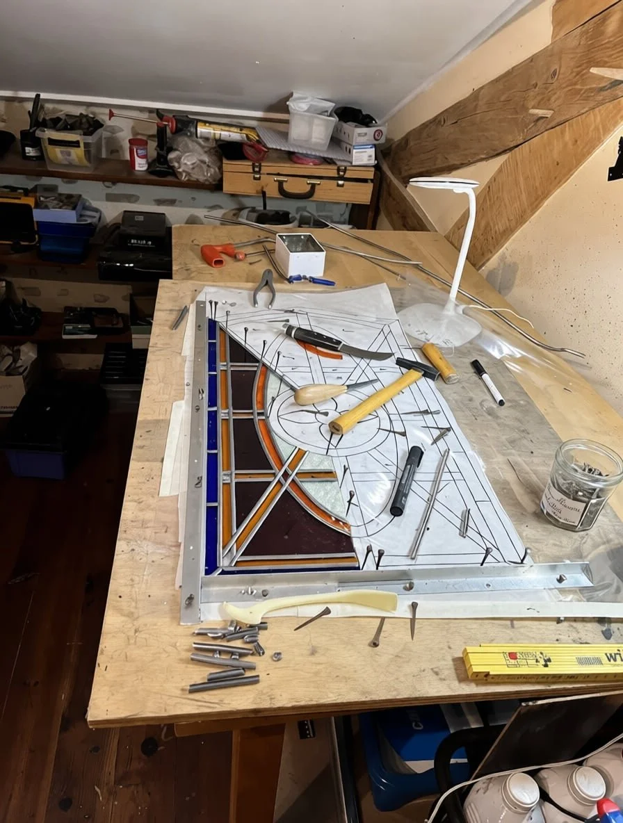Stained glass farm door window restoration workshop, showing detailed lead came work and textured glass