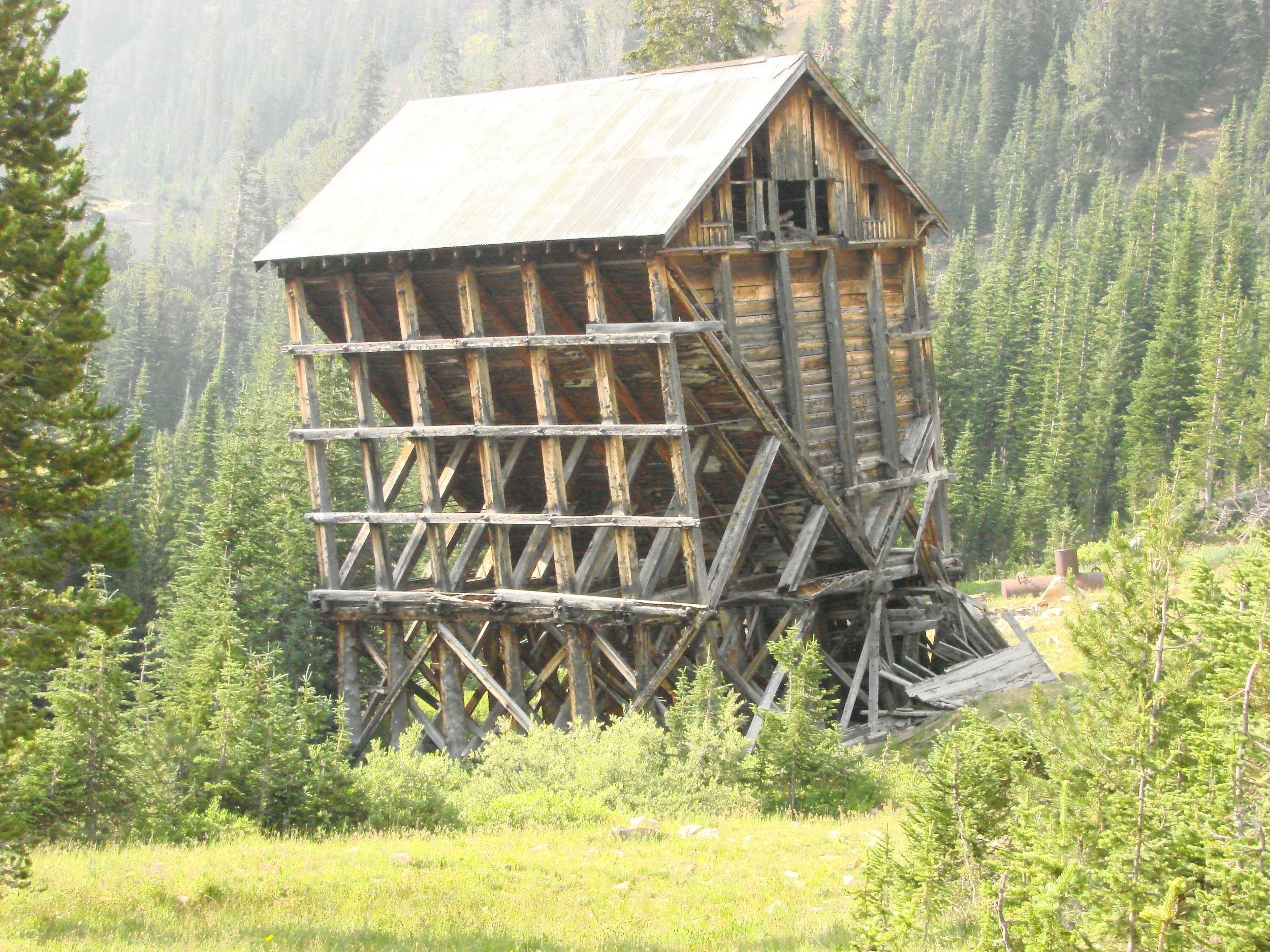Abandoned wooden mining structure surrounded by forest