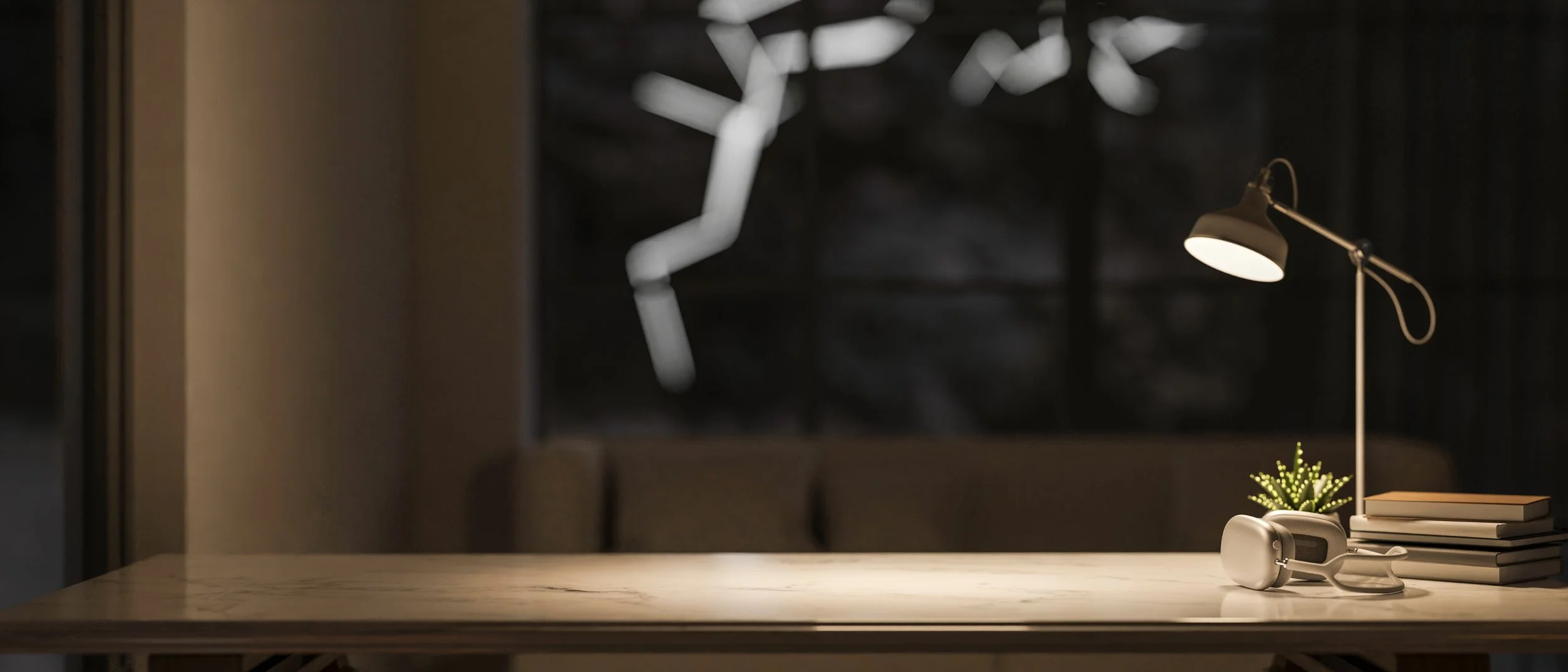 A modern desk lamp on a light-colored marble table, with a stack of books, a small potted succulent, and a white virtual reality headset. The background is dark and blurred.