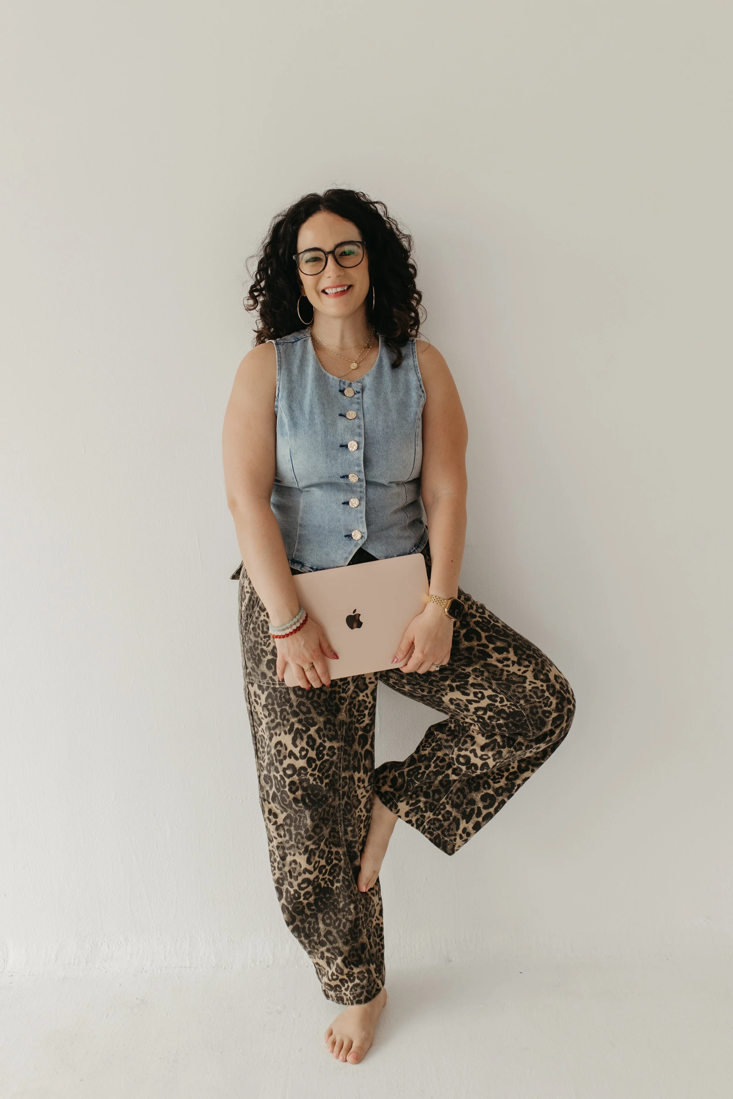 Carly Shadid, LMFT, holding a laptop, offering telehealth and in-person therapy