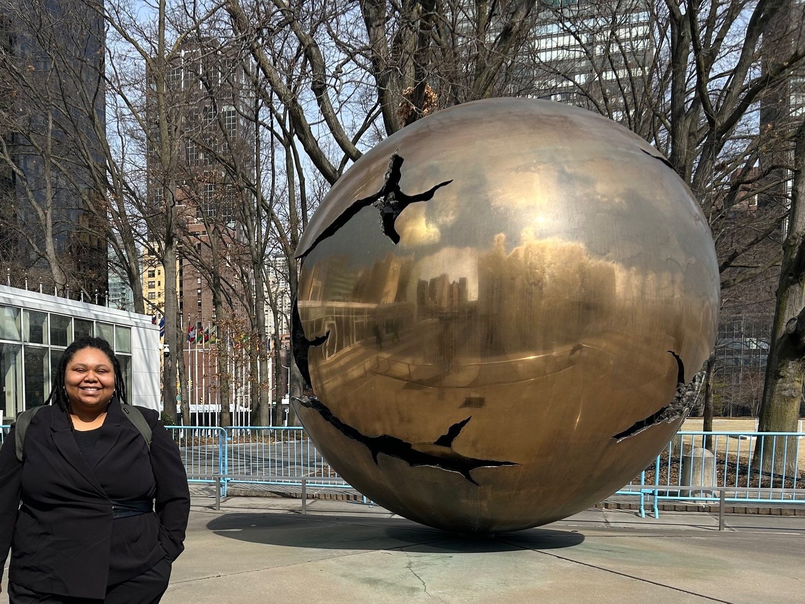 Dr. Forté in front of a large brass globe at the United Nations NYC headquarters