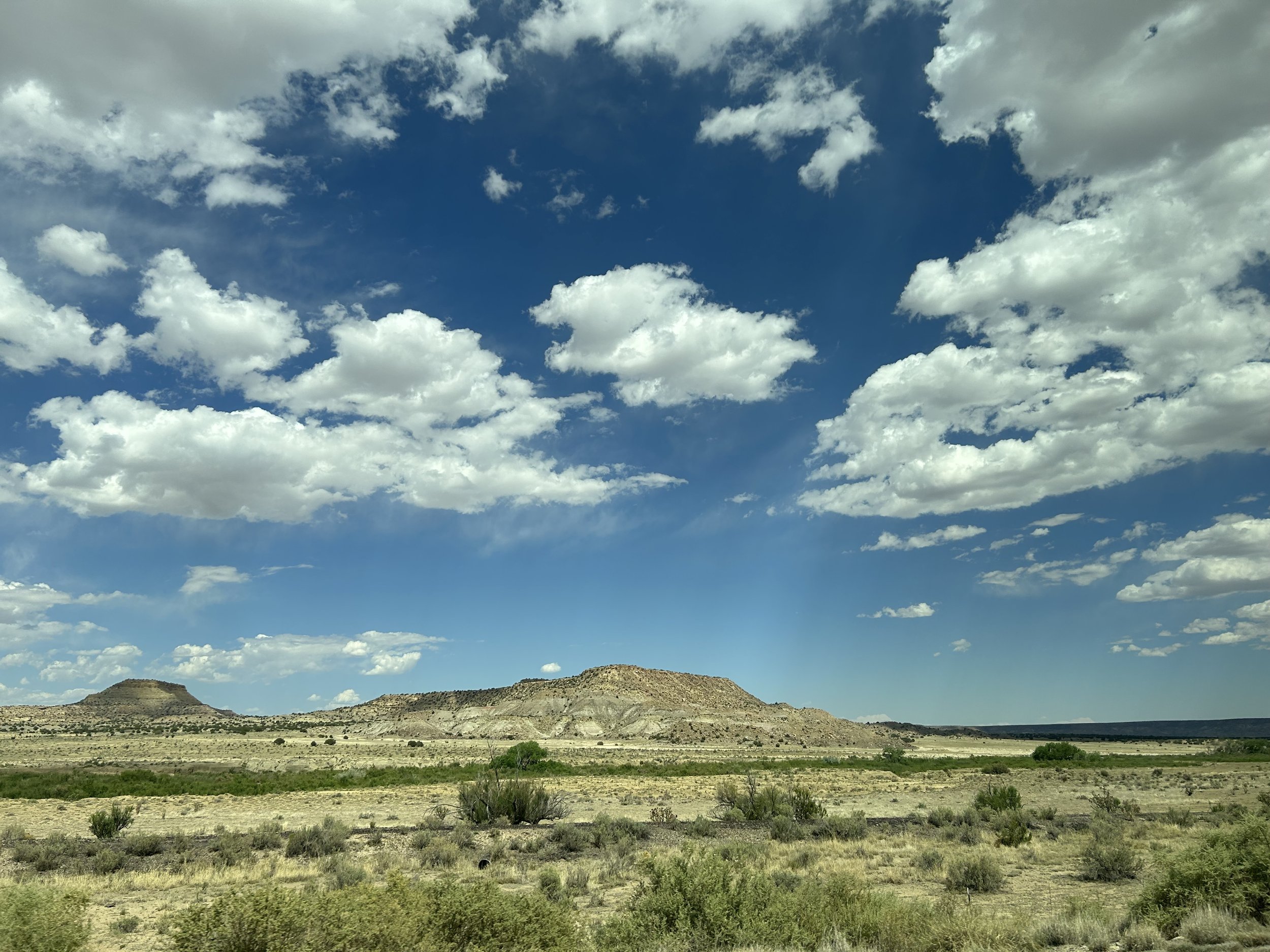 A photo of clouds above hills in NM.