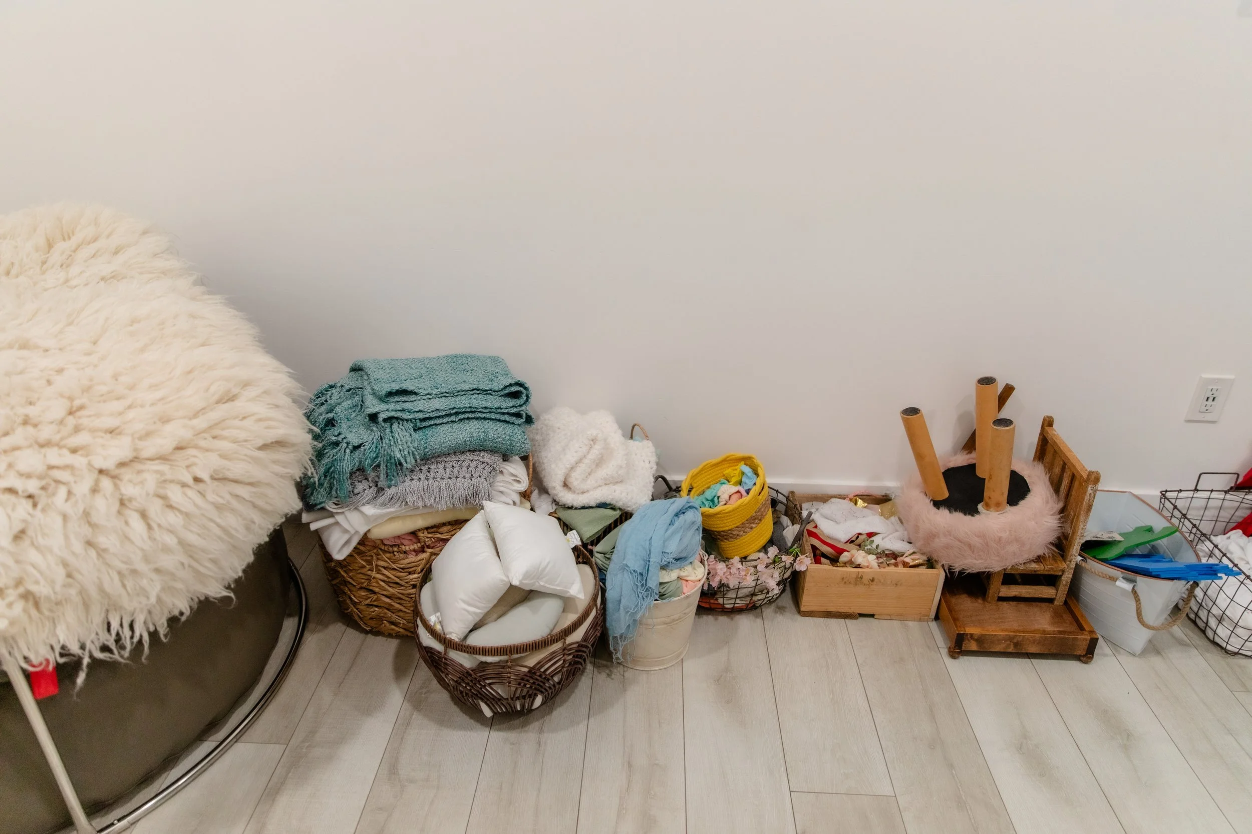 Organized newborn photography props including wraps, blankets, pillows, and baskets in Studio C at Varsa Studios American Fork, thoughtfully styled for professional newborn photographers.