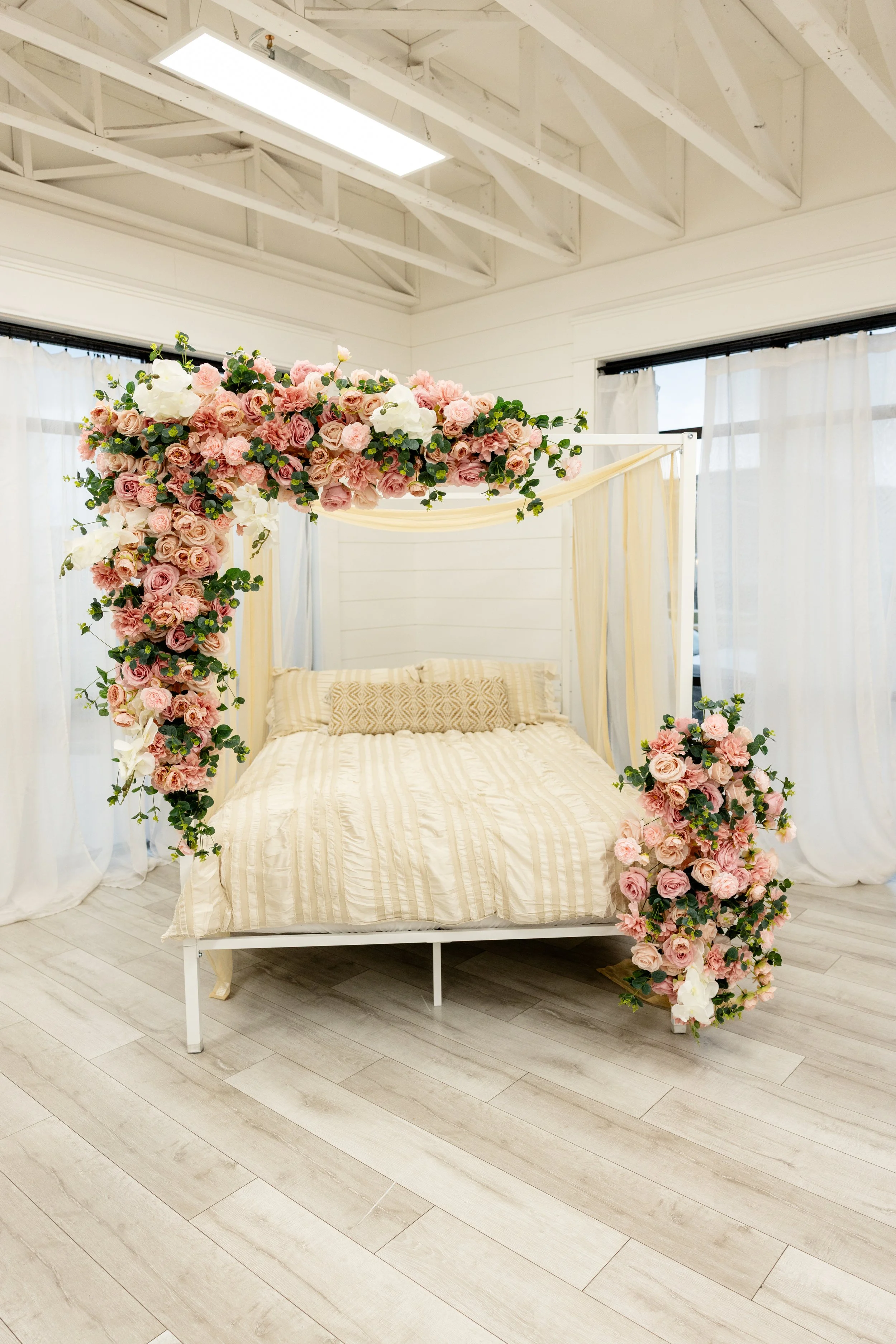 Floral canopy bed installation in natural light studio rental in American Fork Utah, romantic photography backdrop for boudoir sessions, maternity photography, branding content, Valentine’s mini sessions and lifestyle photography studio in Utah Count