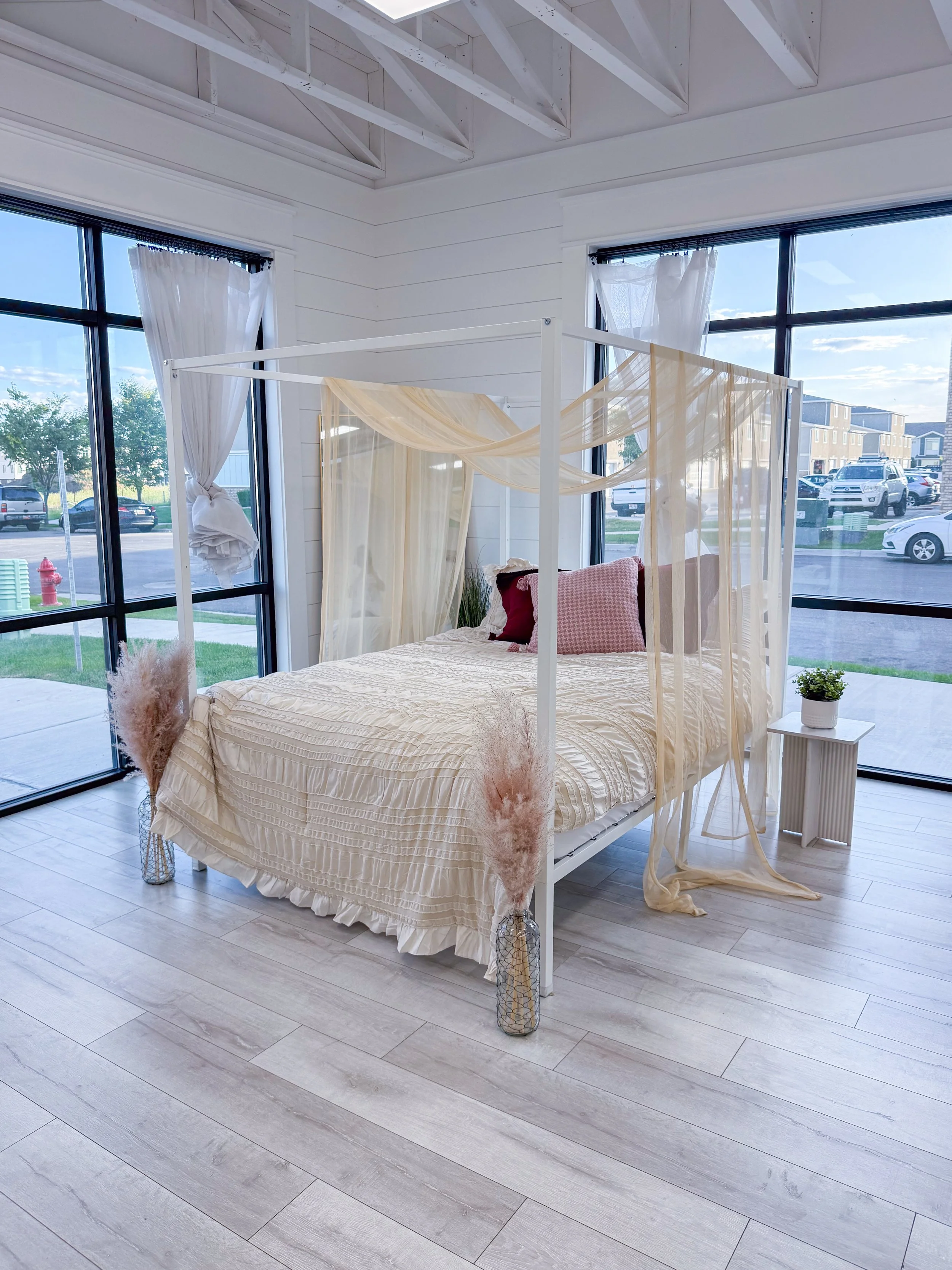 Elegant white canopy bed styled with flowing drapery, textured bedding, and soft neutral decor. Perfect for boudoir photography, maternity sessions, couples photography, branding content, motherhood sessions, lifestyle portraits, and editorial photog