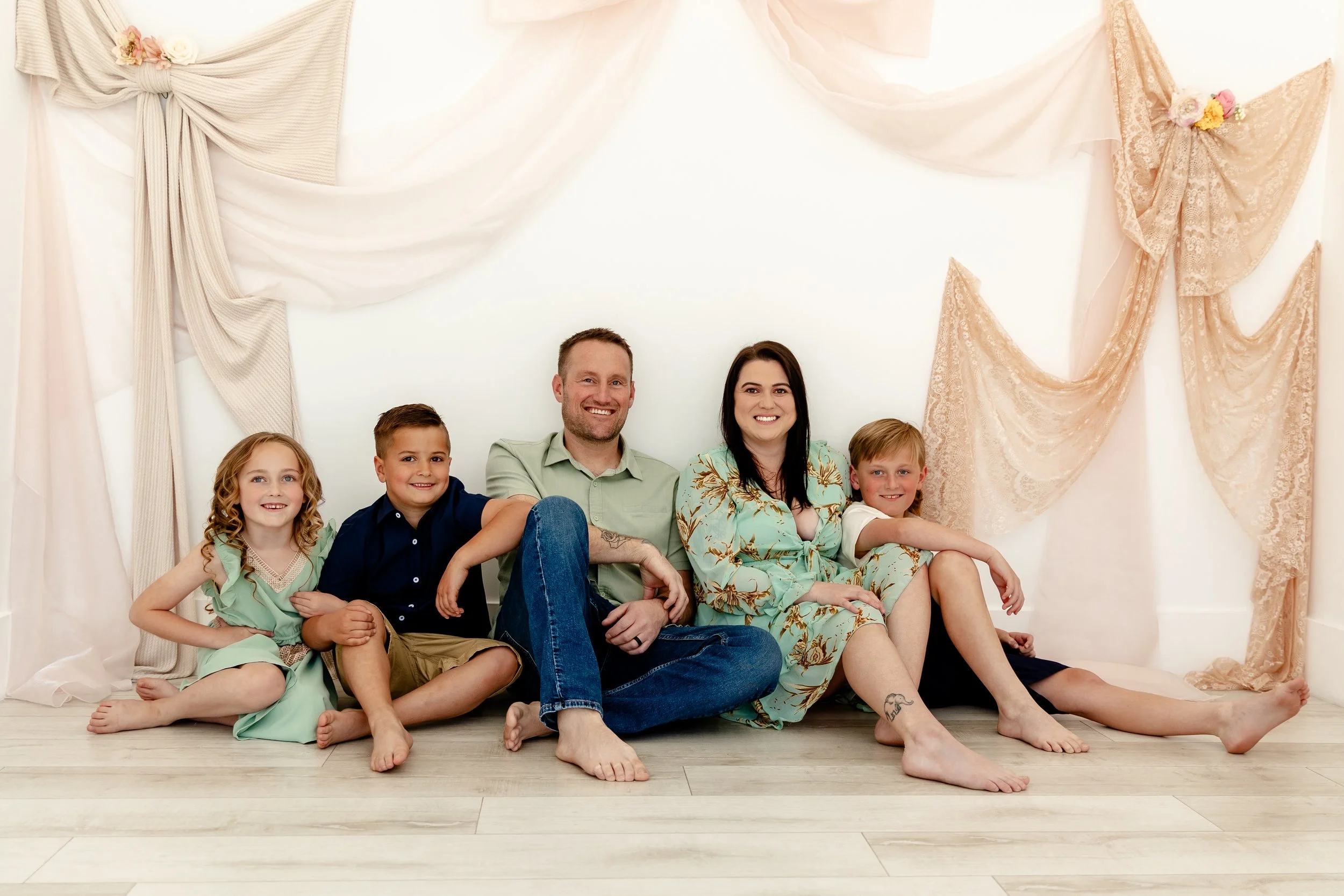 Family portraits in a soft neutral natural light Utah studio with custom fabric backdrop, ideal for lifestyle and motherhood sessions.