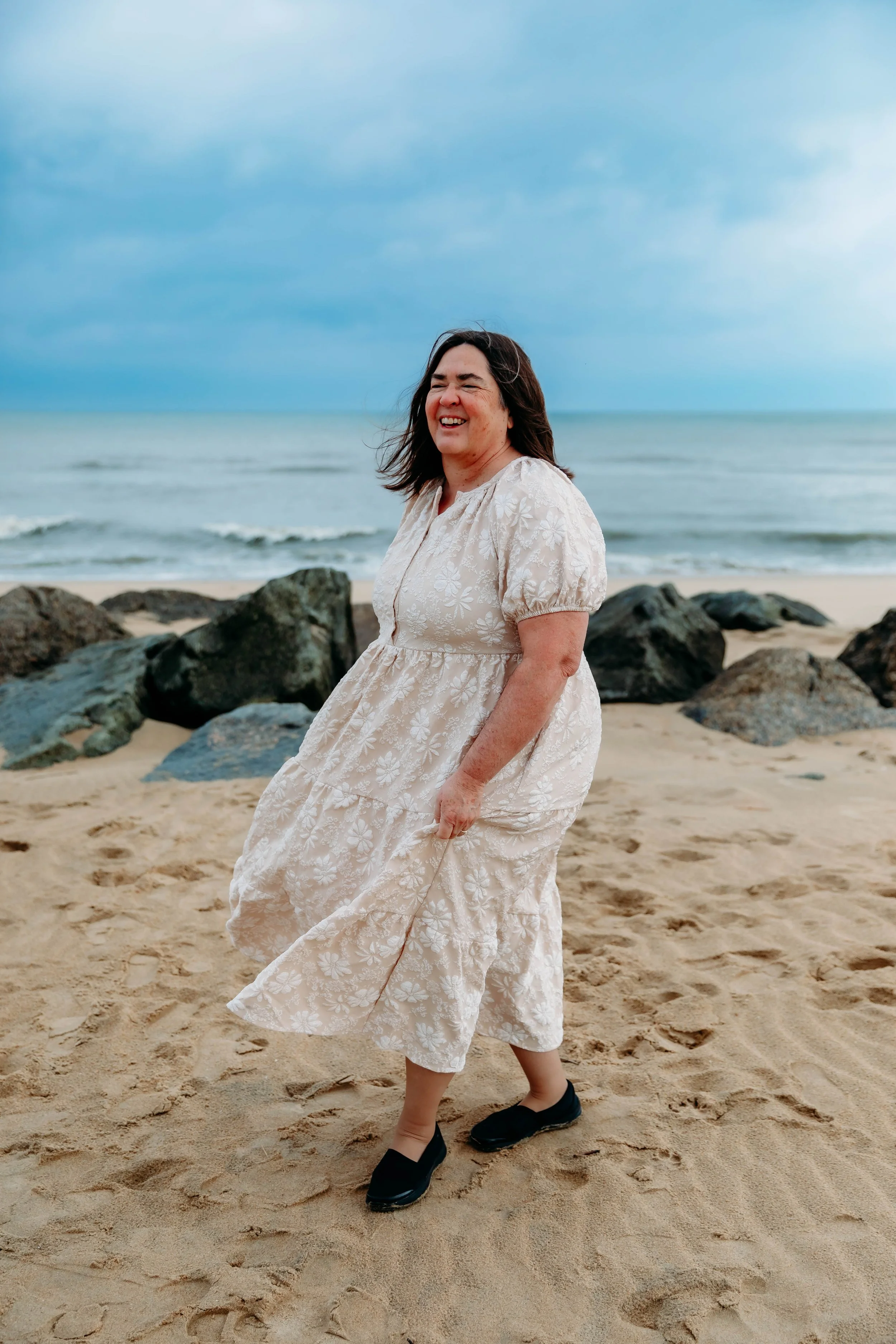 Outdoor portrait session at the beach with woman in flowing dress, captured for photography studio rental portfolio.