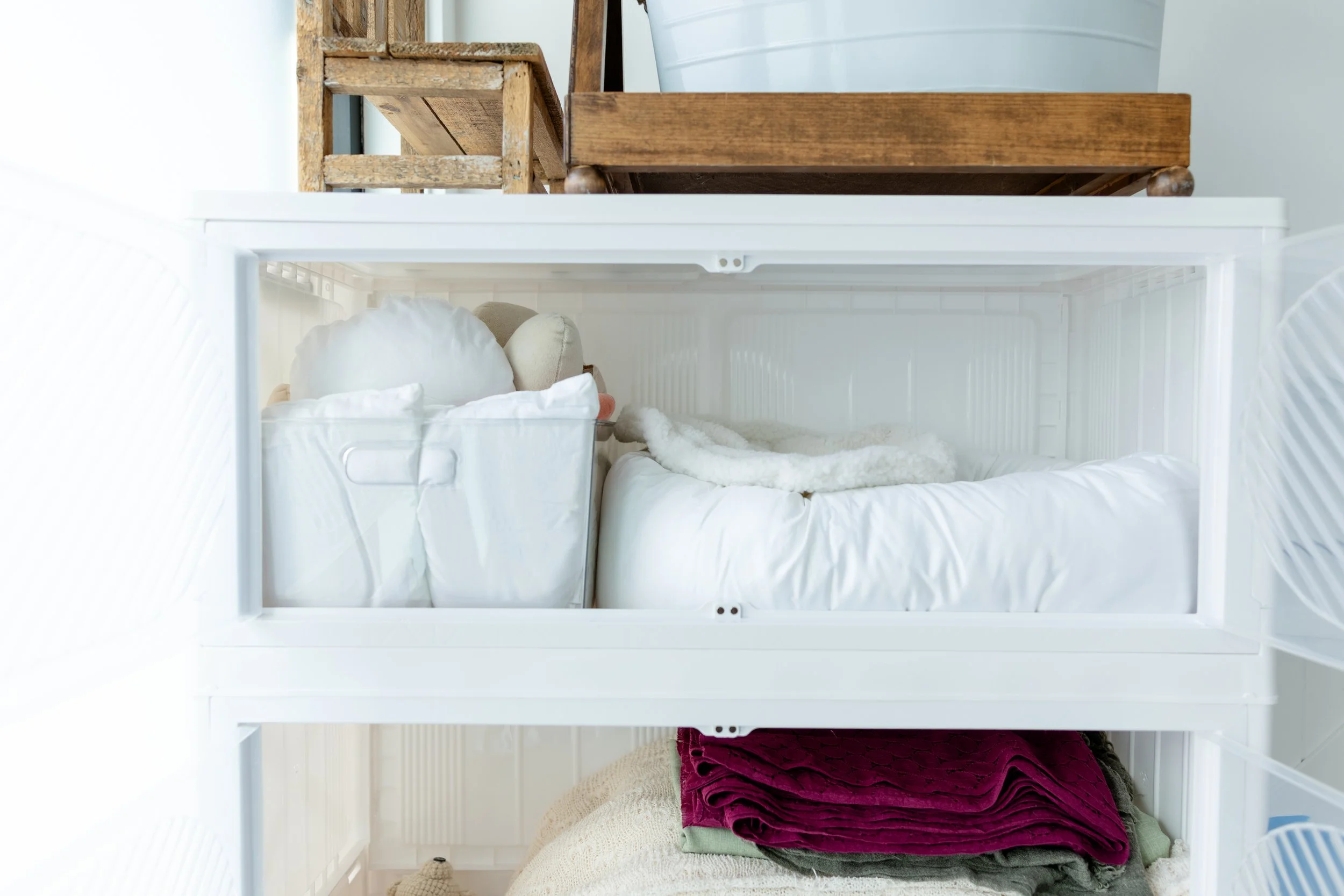 Close-up of newborn photography pillows, blankets, and posing materials stored inside Studio C at Blank Space American Fork.
