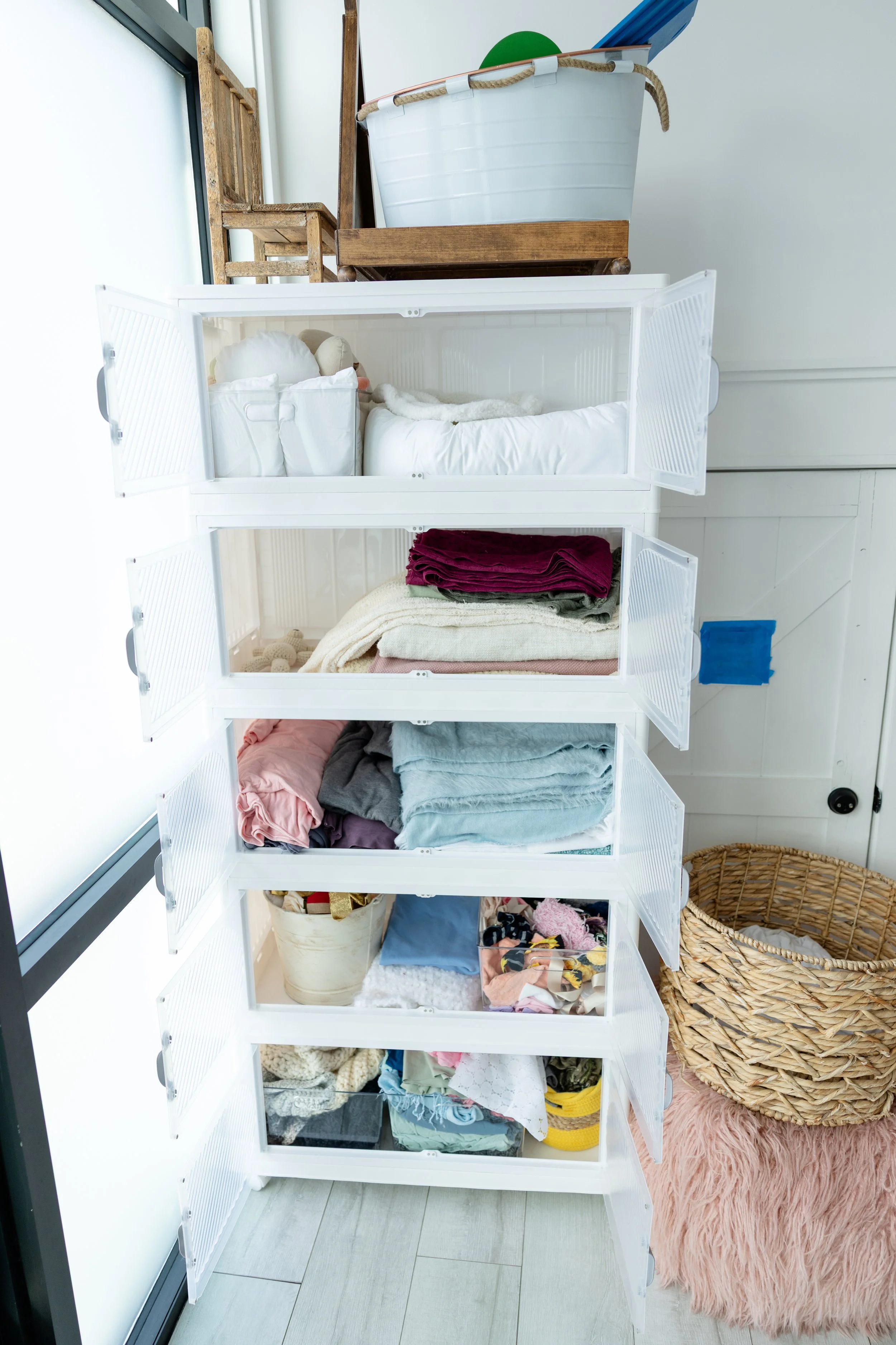 Open newborn photography prop drawers in Studio C at Blank Space American Fork displaying folded wraps, textured fabrics, and accessories for studio use.