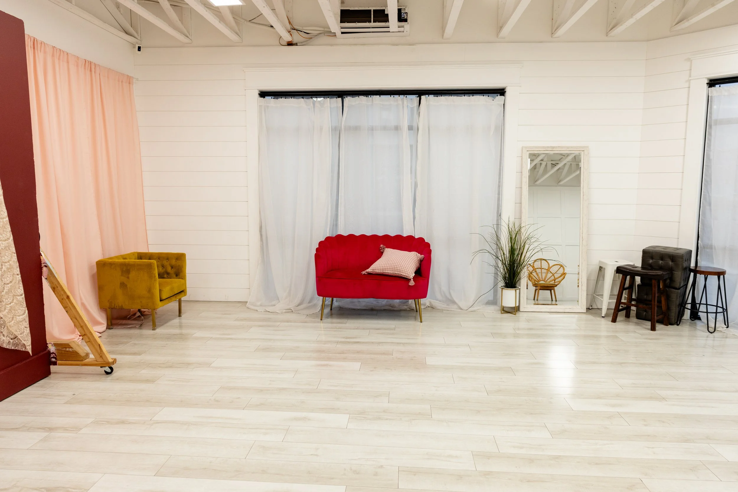 This corner of Studio A highlights our natural light windows paired with bold seating options for lifestyle photography and branding sessions. The soft curtains diffuse light beautifully, making it a favorite for content creators and photographers se