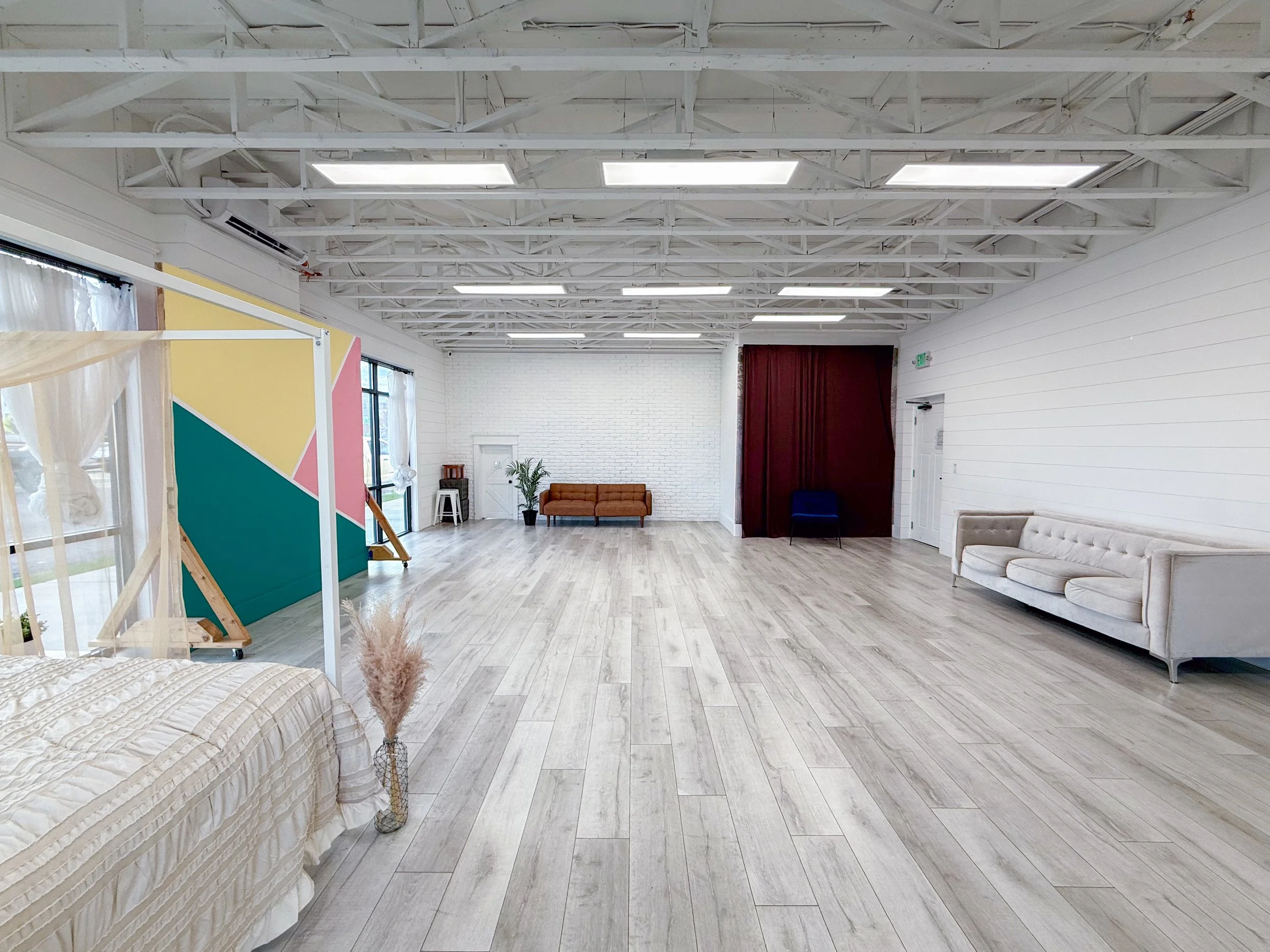 Spacious photography and content creation studio featuring floor-to-ceiling windows, multiple shooting areas, movable feature walls, lifestyle furniture, and abundant natural light. Designed for photographers, videographers, influencers, entrepreneur