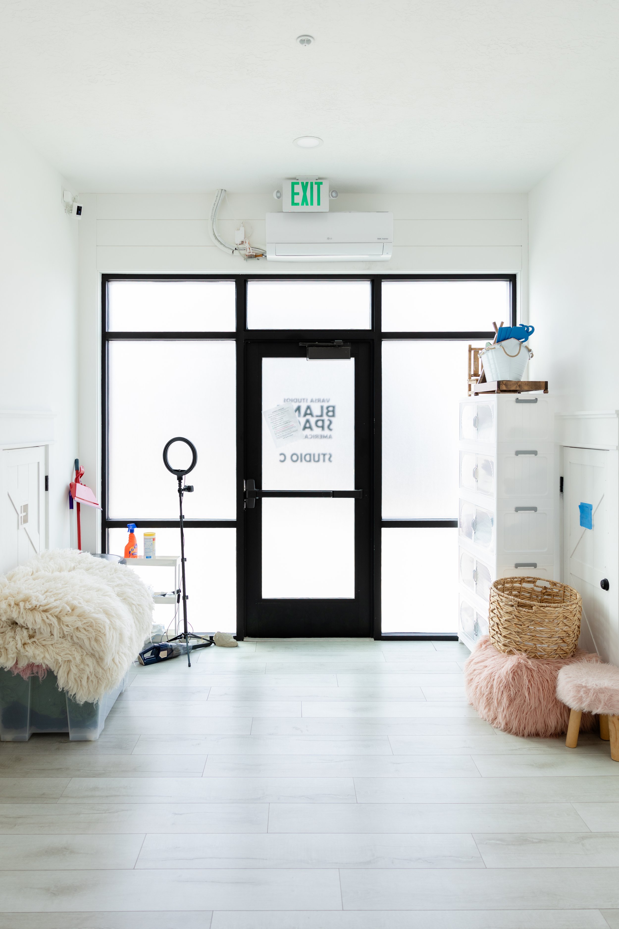 Wide view of Studio C at Blank Space in American Fork, Utah, showing a bright newborn photography studio with large windows, white walls, and organized newborn props.