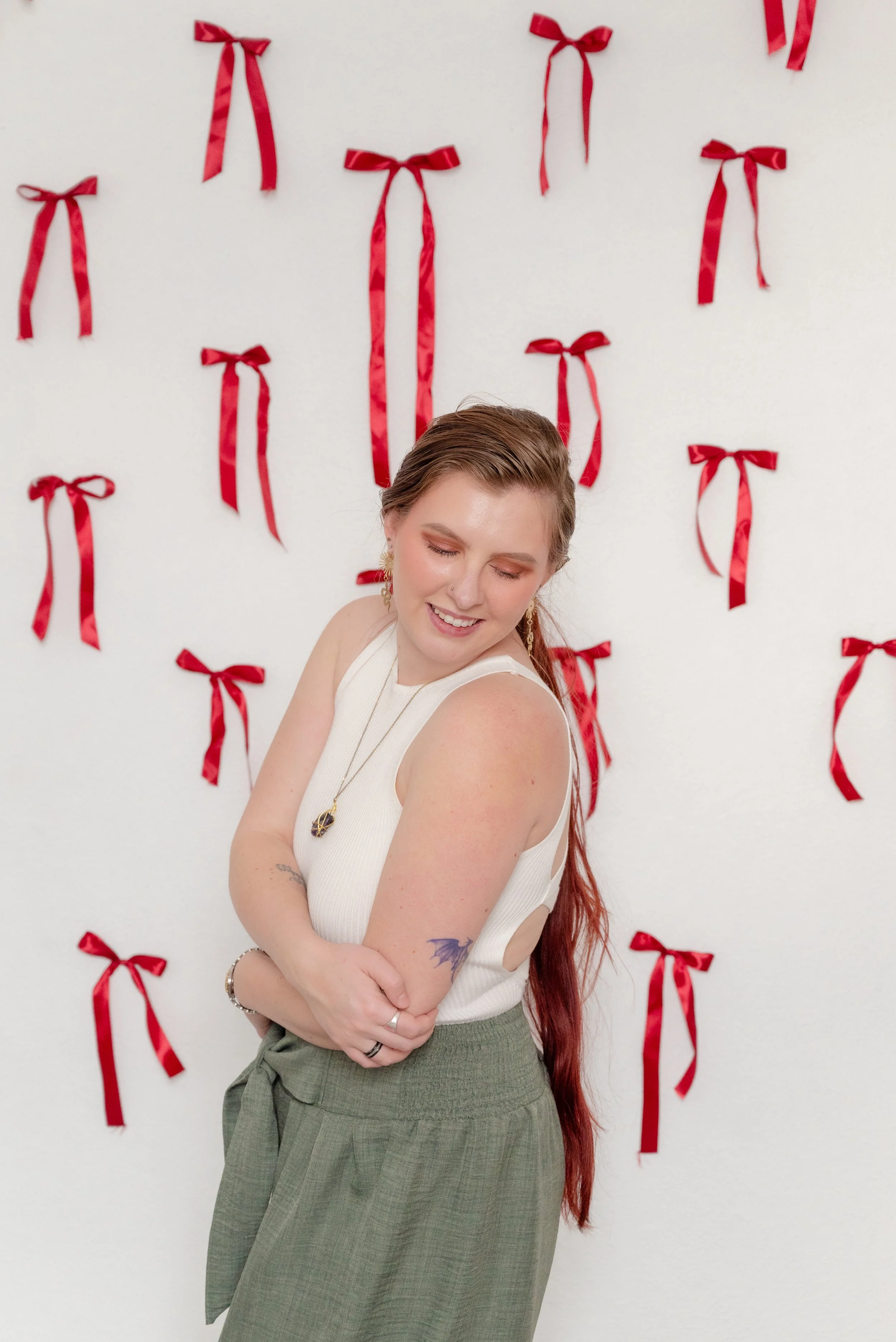 Close-up portrait of a woman with soft makeup and long hair photographed in The Alcove studio in Springville, Utah, using a Valentine ribbon backdrop.