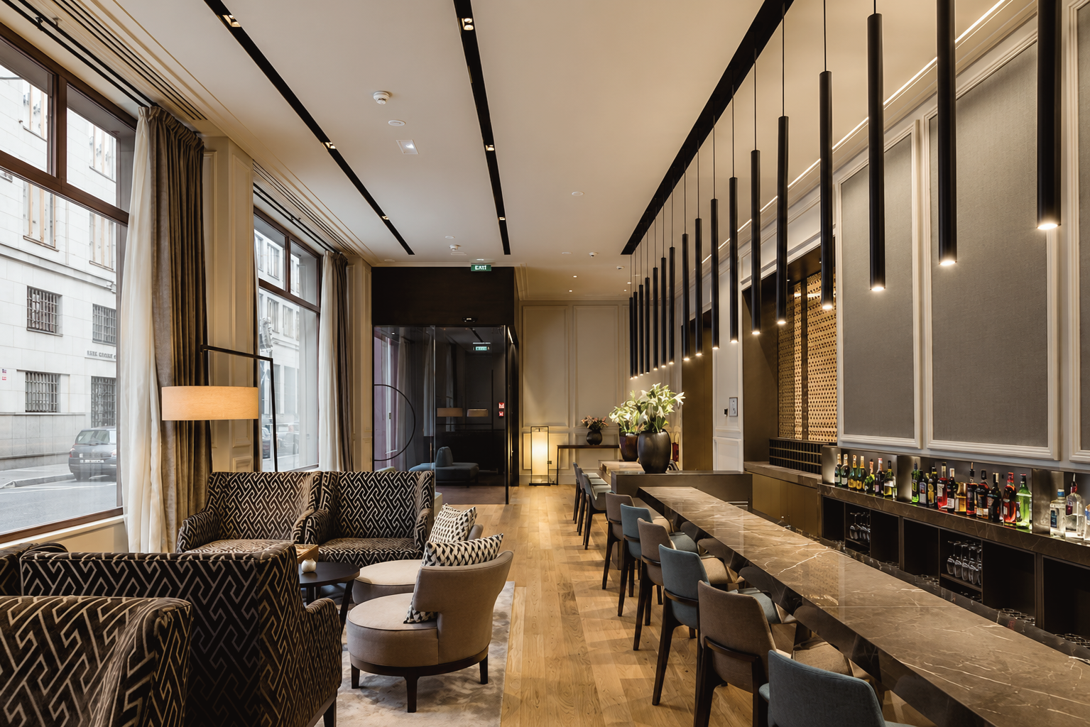 Contemporary lounge and bar at BoHo Prague Hotel in Prague, Czech Republic, featuring modern pendant lighting, patterned seating, warm wood floors, and refined neutral interiors.