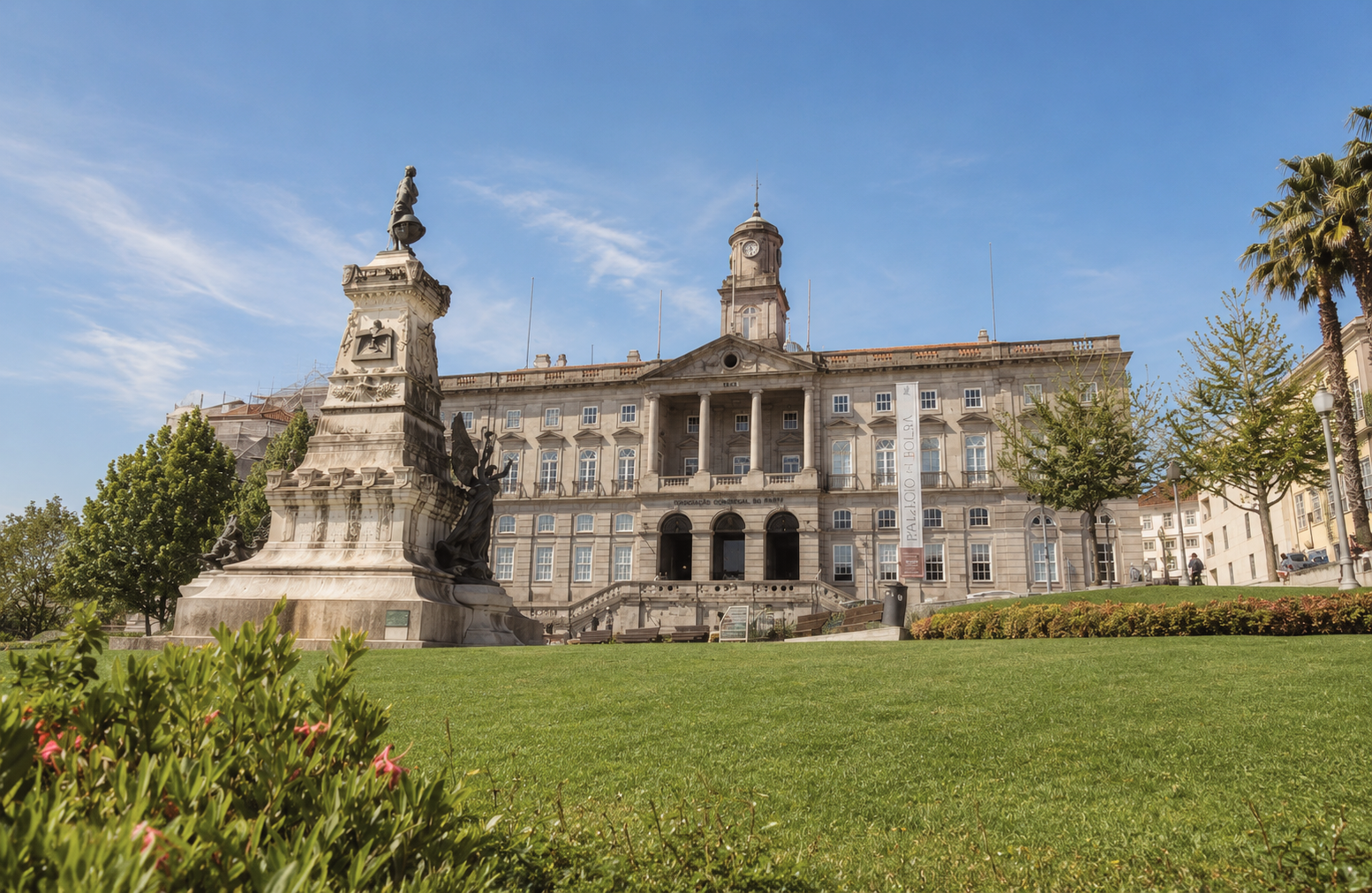 Palácio da Bolsa in Porto, Portugal, with its grand neoclassical façade, landscaped lawn, and monument in the foreground.