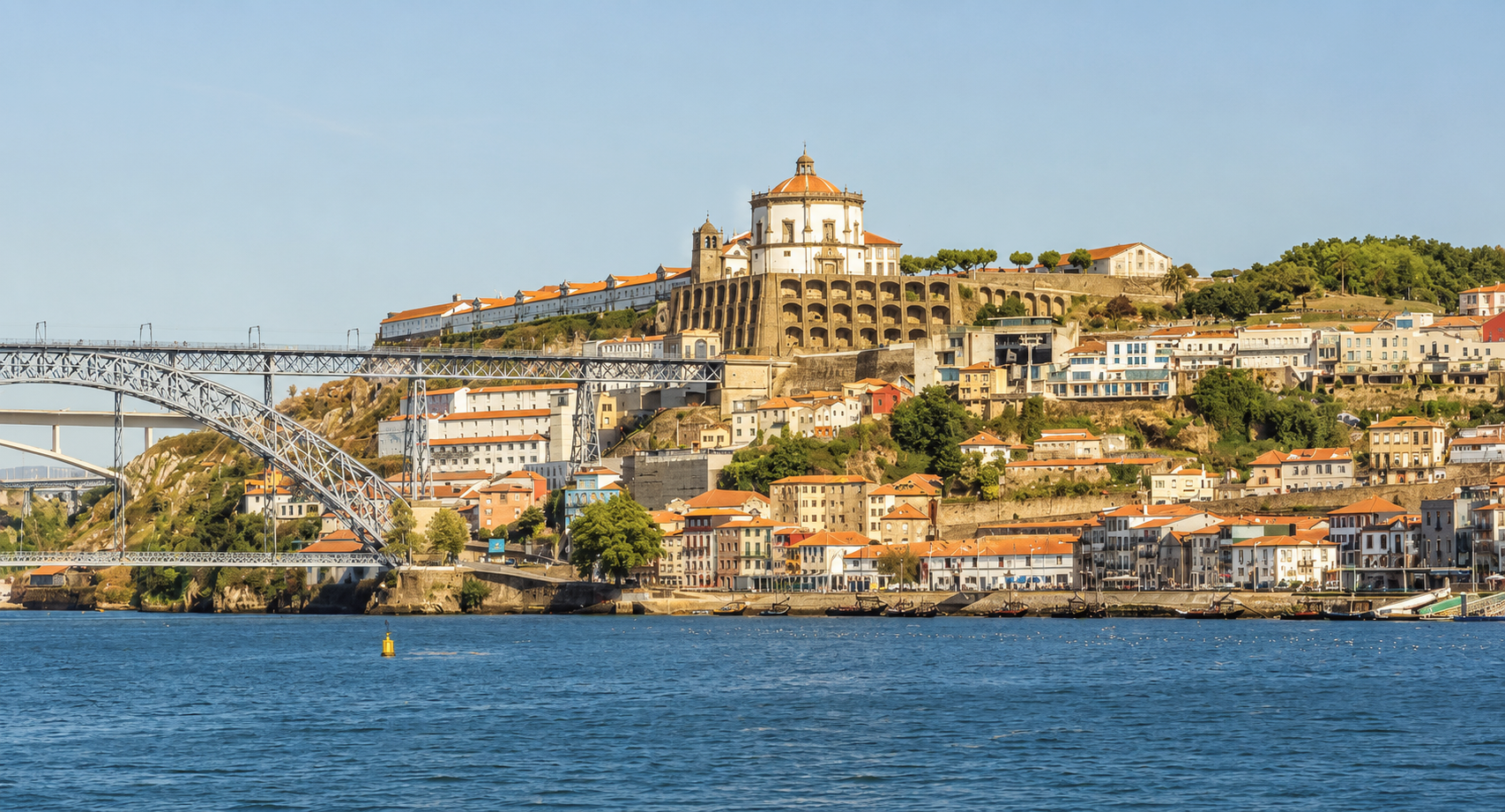 Vila Nova de Gaia in Porto, Portugal, with the Douro River, Dom Luís I Bridge, hillside architecture, and Serra do Pilar Monastery.