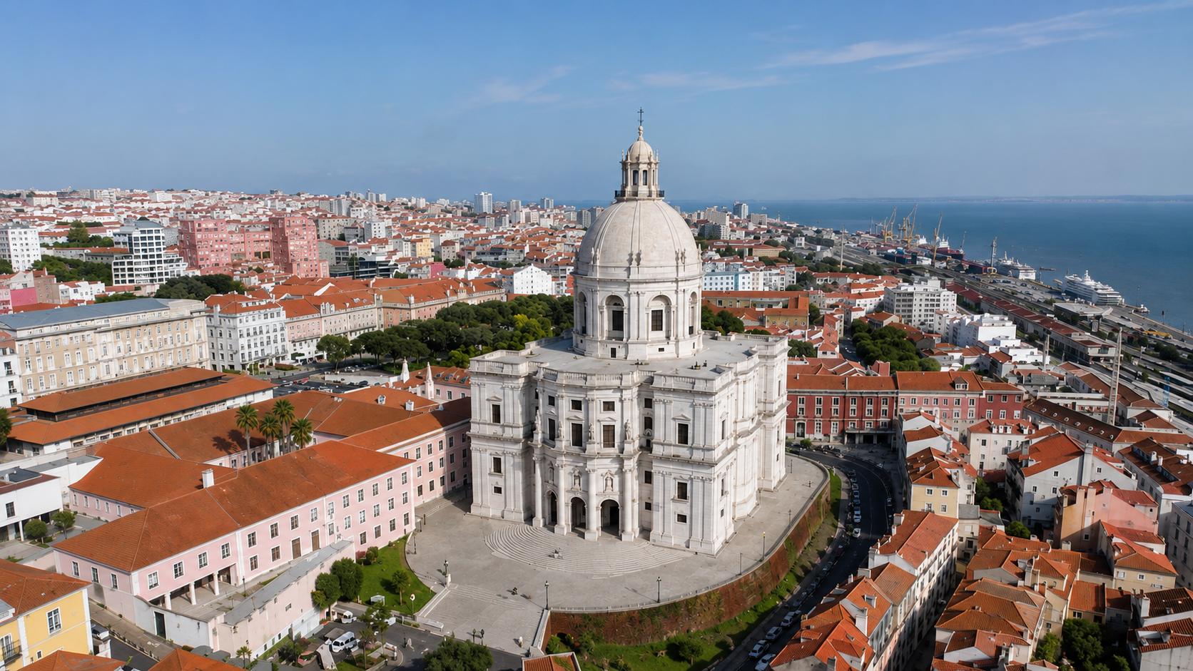 Aerial view of the National Pantheon in Lisbon, Portugal, surrounded by Alfama’s terracotta rooftops, historic buildings, and the Tagus River.