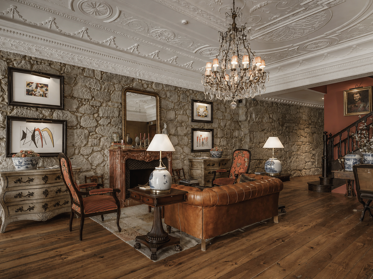 M Maison Particulière luxury boutique hotel in Porto, Portugal, featuring an elegant historic lounge with stone walls, chandelier, antique furnishings, and refined interiors.