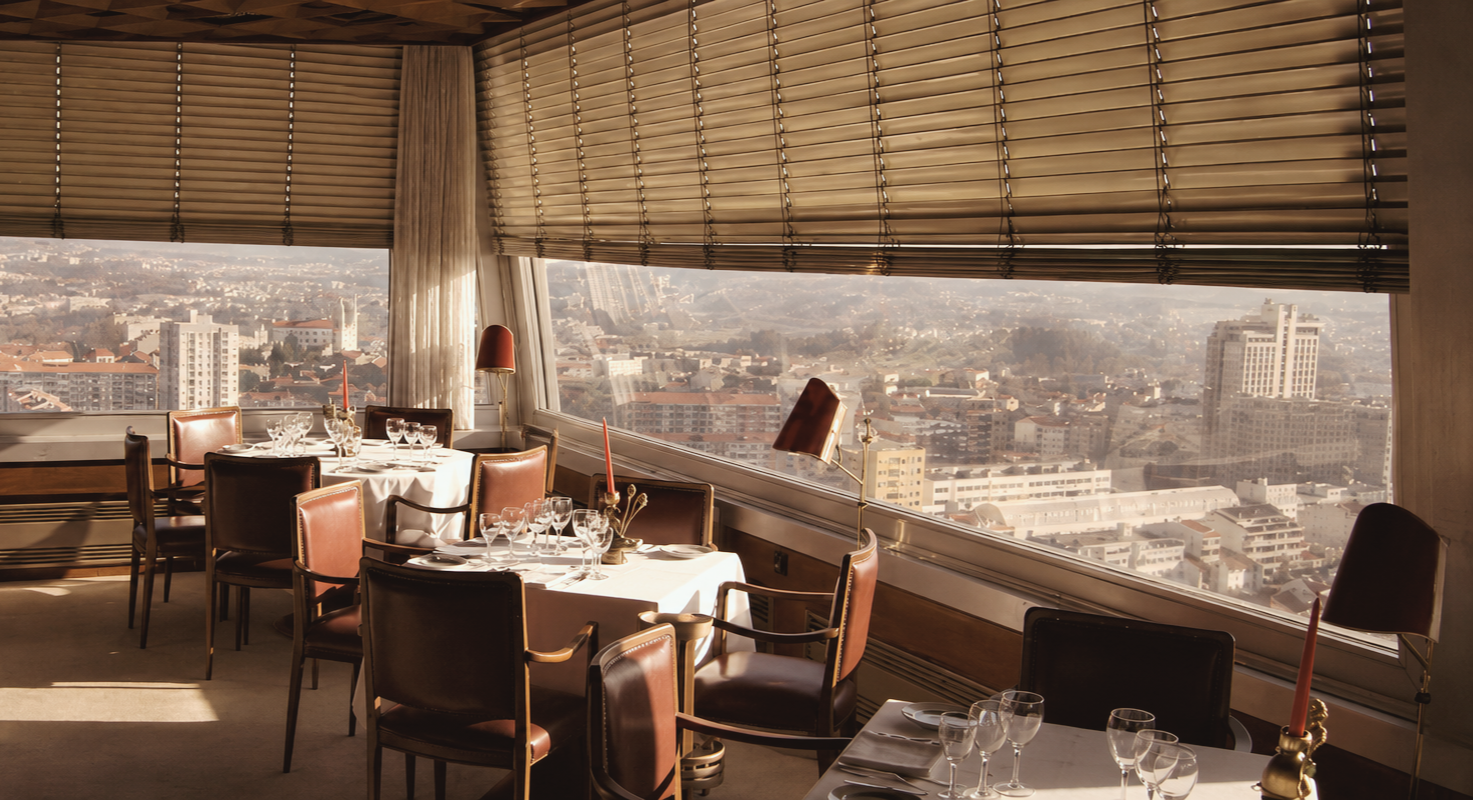 Portucale Restaurant in Porto, Portugal, featuring an elegant dining room with panoramic city views, refined table settings, and warm natural light.