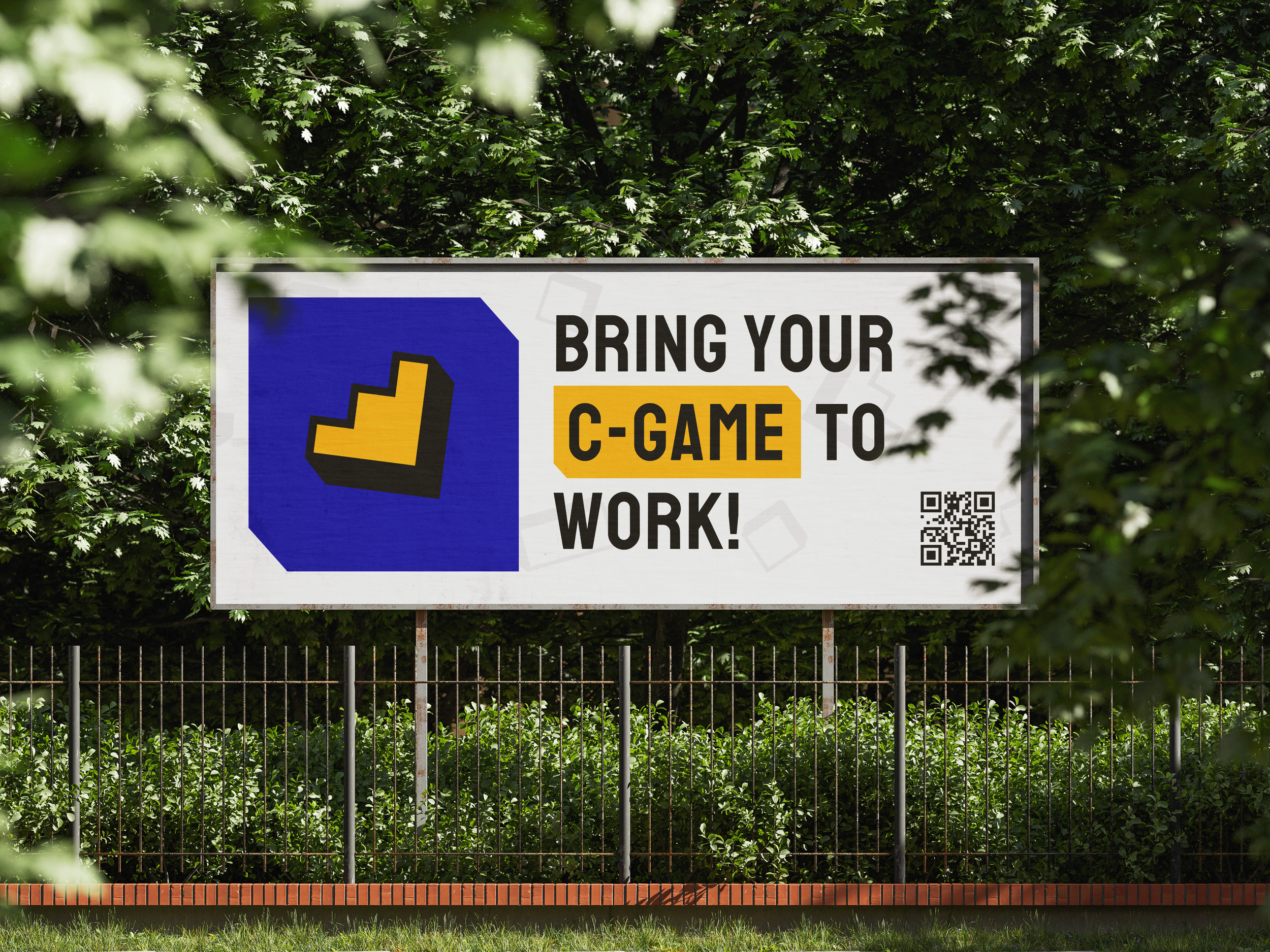 Sign saying 'Bring Your C-Game to Work!' with a blue and yellow logo, surrounded by green trees and bushes.