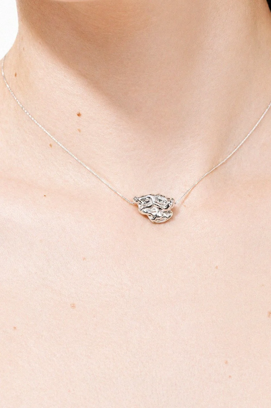 silver-flower-petal-stud-earring-ear-through-torn-paper.png