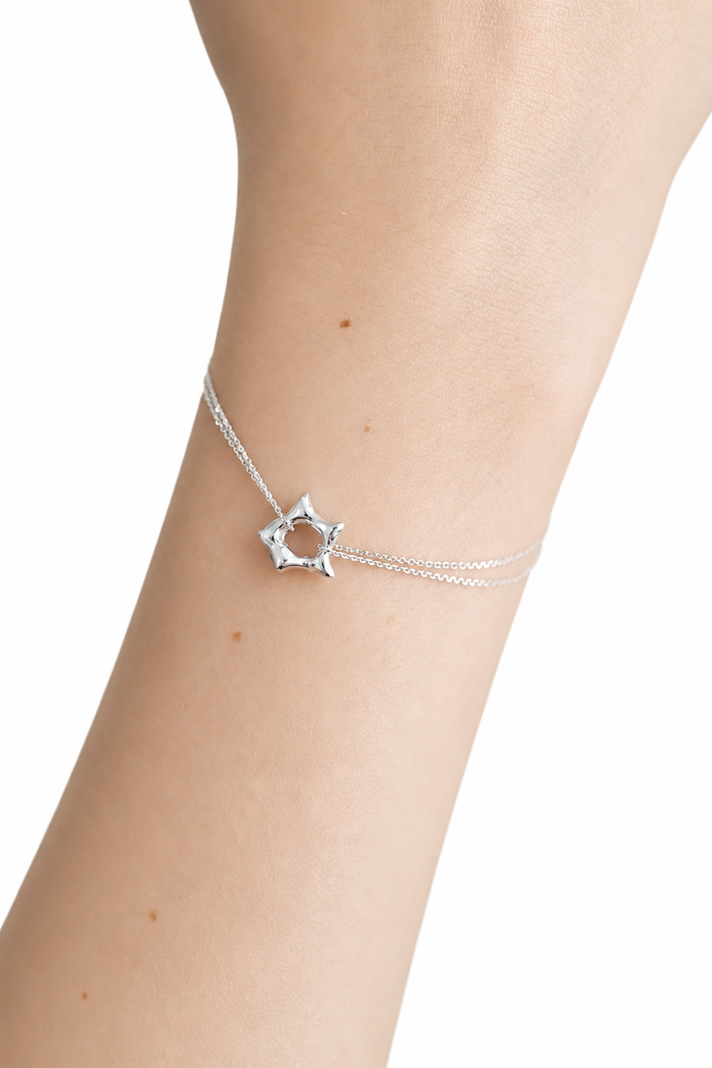 silver-star-charm-bracelet-on-wrist.png