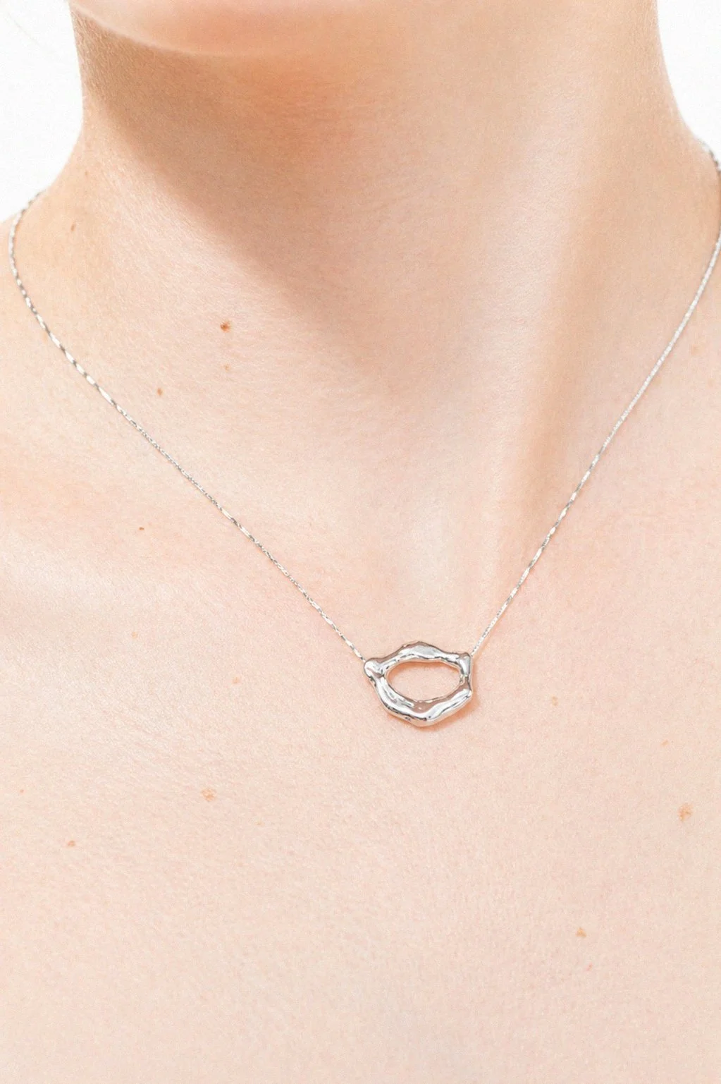 silver-long-wavy-drop-earring-ear-through-torn-paper.png