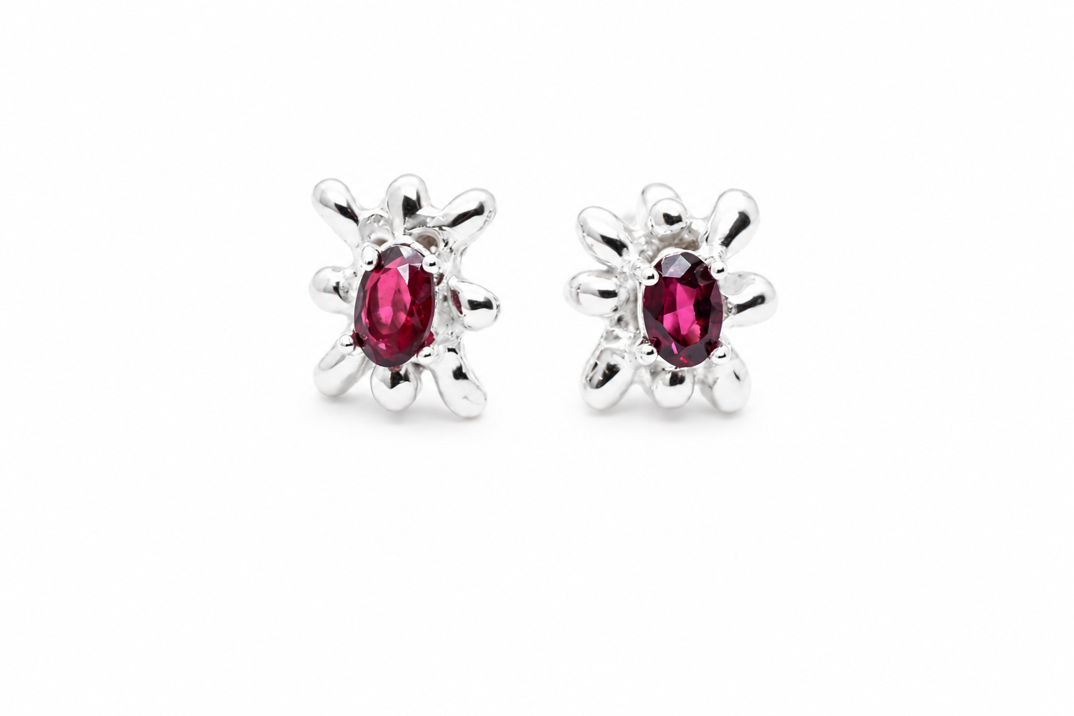 silver-ruby-oval-stud-earrings-with-spike-halo.png