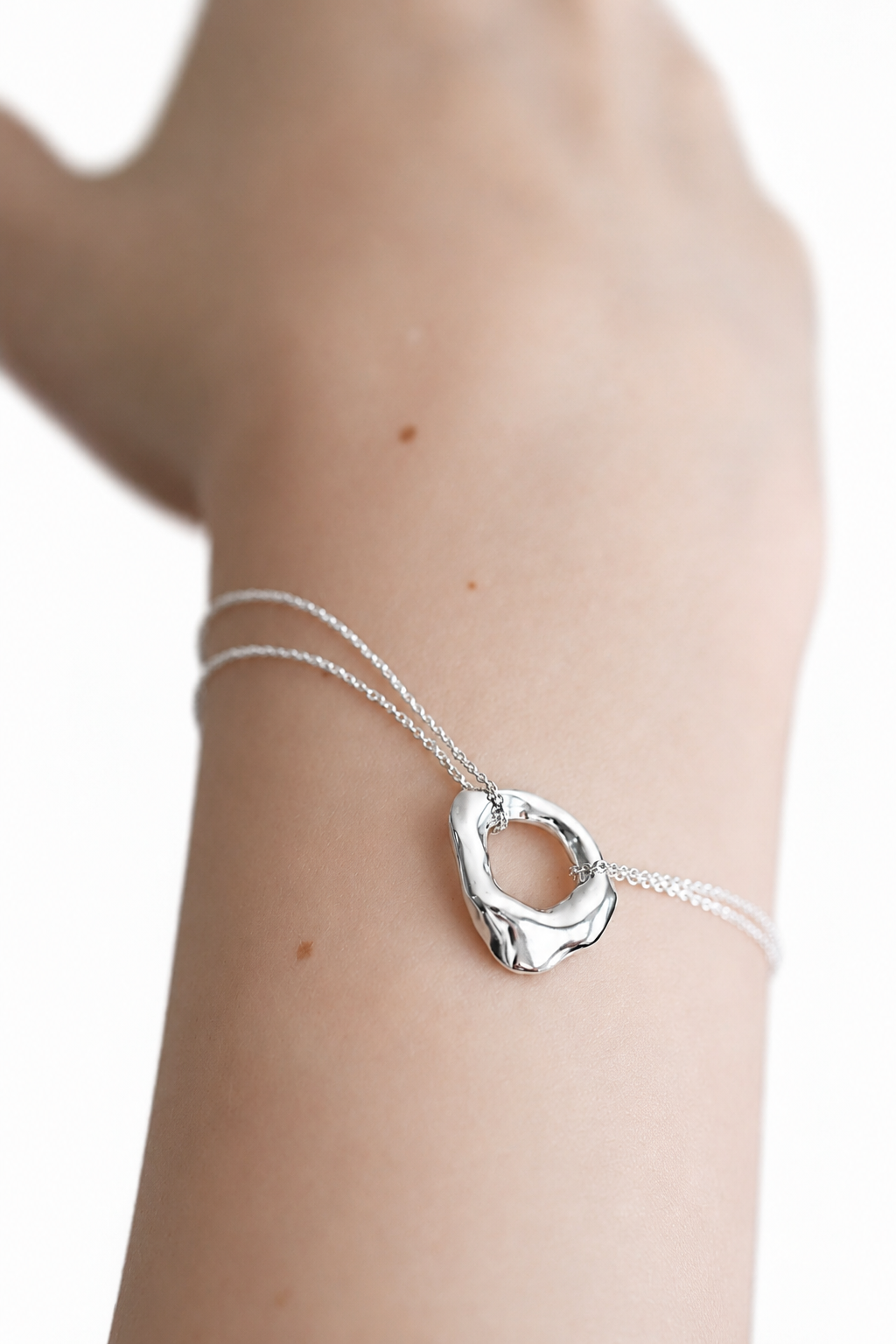 silver-organic-circle-pendant-bracelet-close-up.png