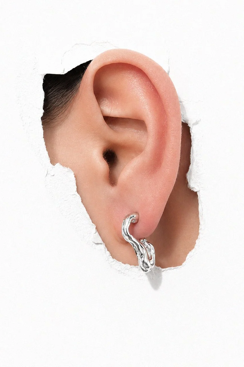 silver-long-drop-chain-wavy-charm-earring-ear-through-torn-paper.png