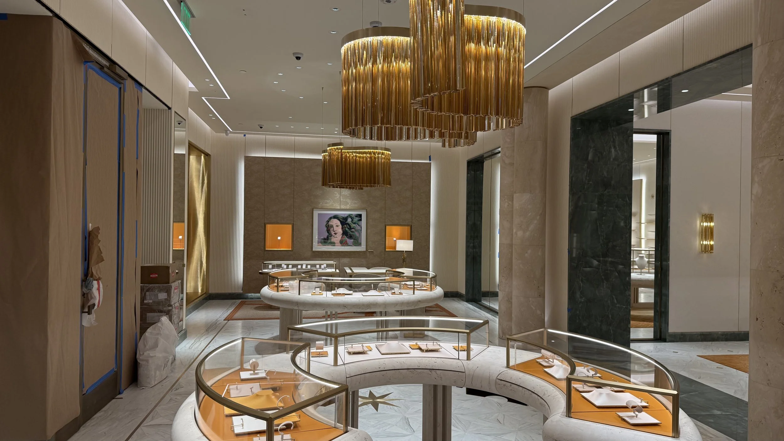 Luxury jewelry store interior with modern lighting, marble floors, and display counters.