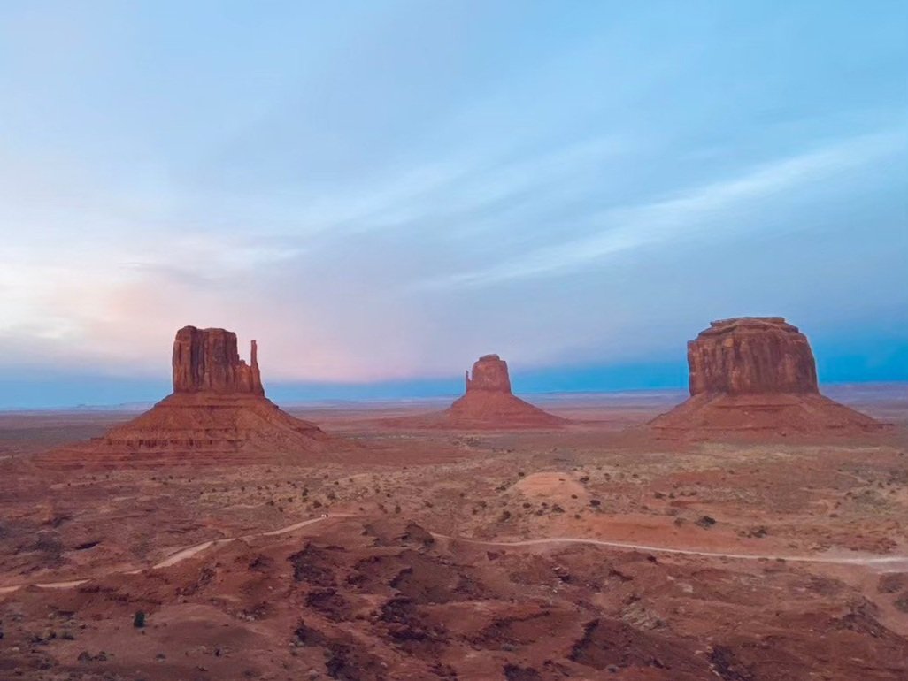 広大な砂漠の風景に三つの巨大な岩の塔が立っている。アメリカ合衆国のユタ州南部からアリゾナ州北部にかけて広がるモニュメントバレーの風景