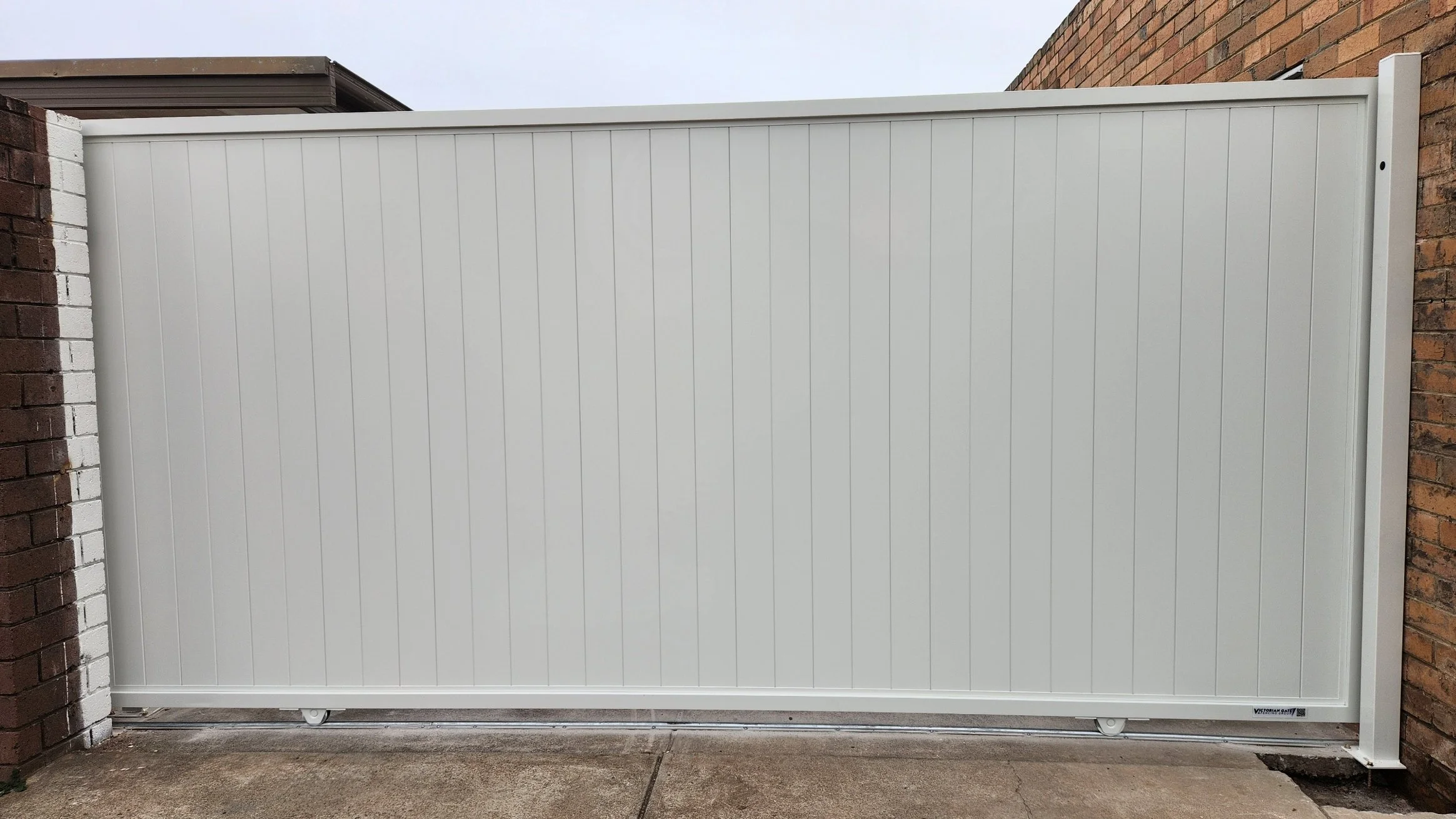 White sliding gate between brick walls