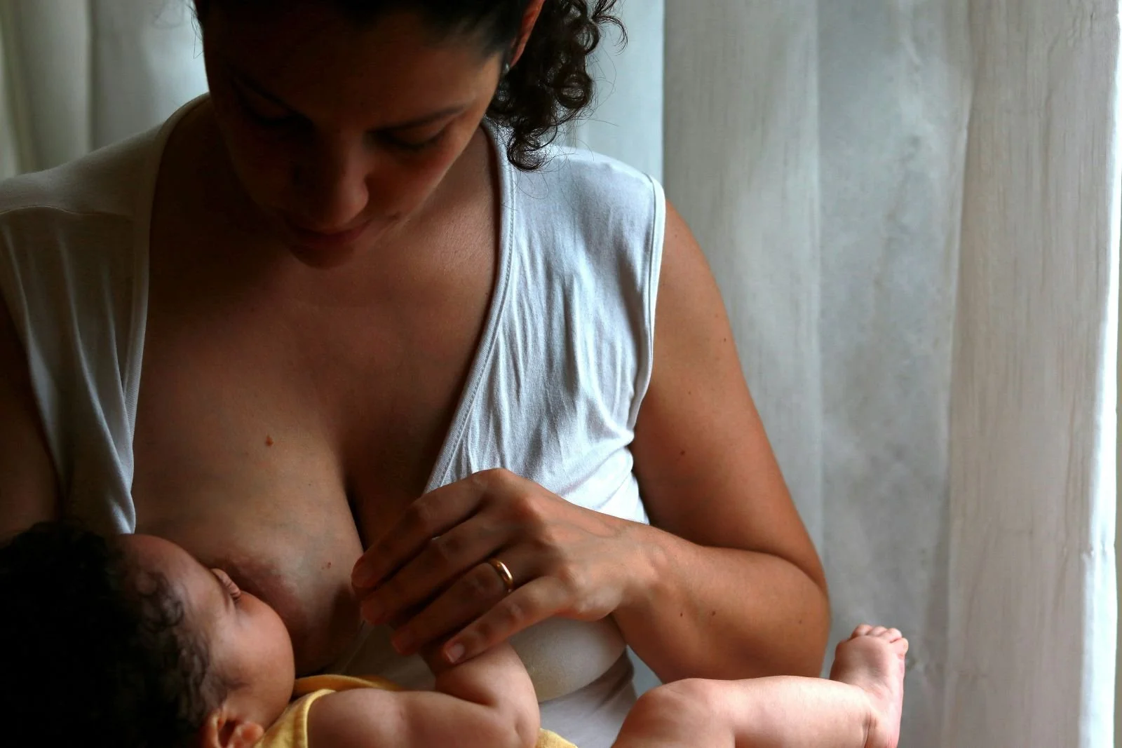 Mother breastfeeding baby while navigating low milk supply concerns in Singapore