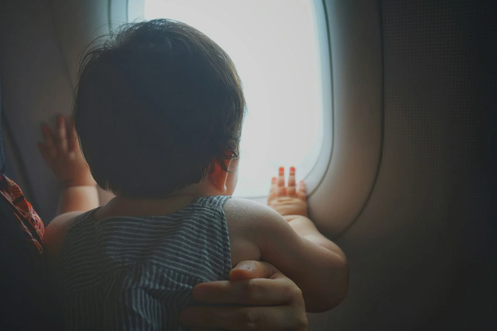 Singapore baby gazing out of train window during family travel journey