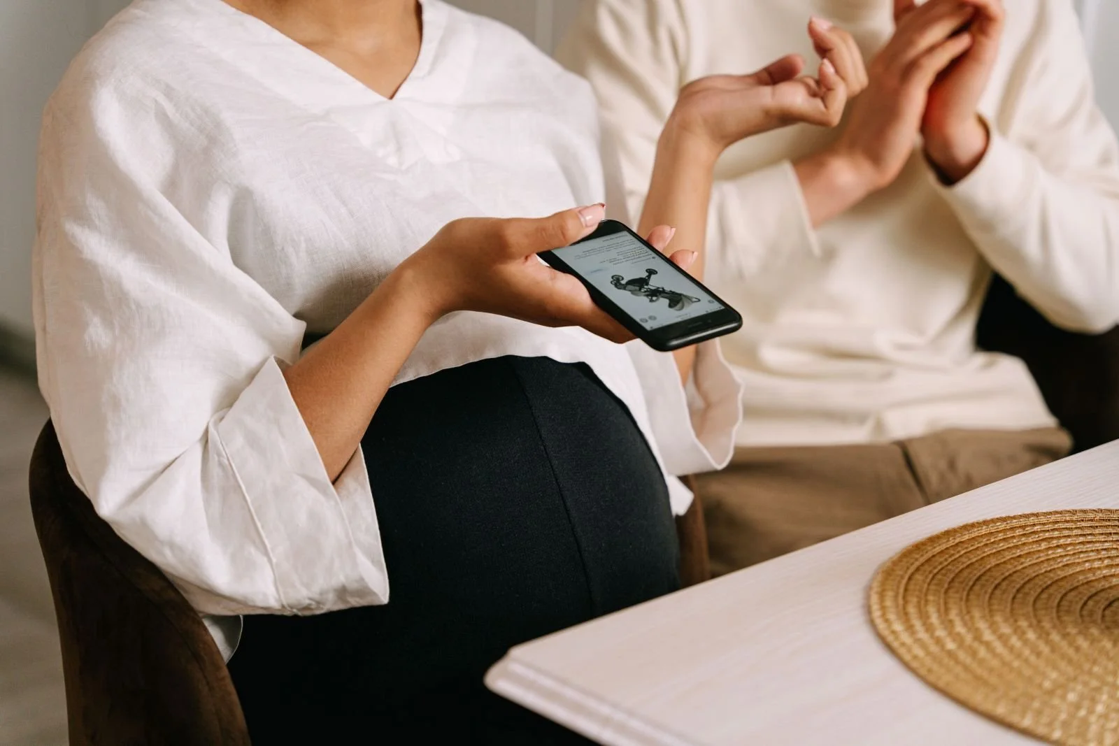 Pregnant woman and partner planning prenatal breastfeeding consult on smartphone