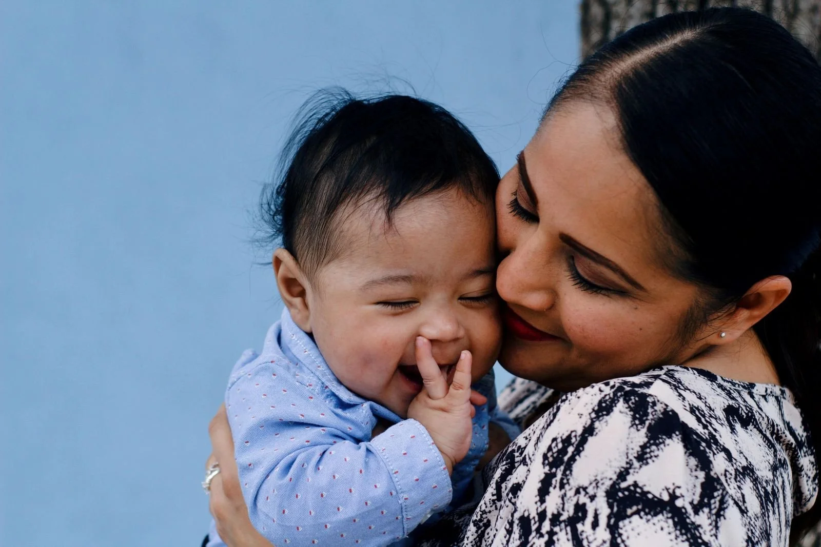 Close-up Photo of Smiling Woman Carrying Her Smiling Baby