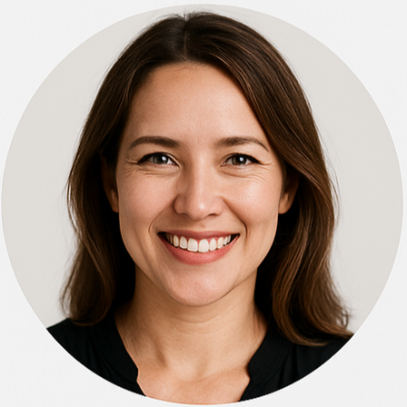 Portrait of a smiling woman with shoulder-length brown hair, wearing a black top, and standing against a plain background.