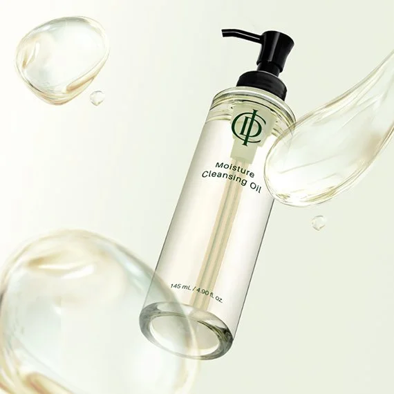 A bottle of moisture cleansing oil with drops of the oil and water around it.