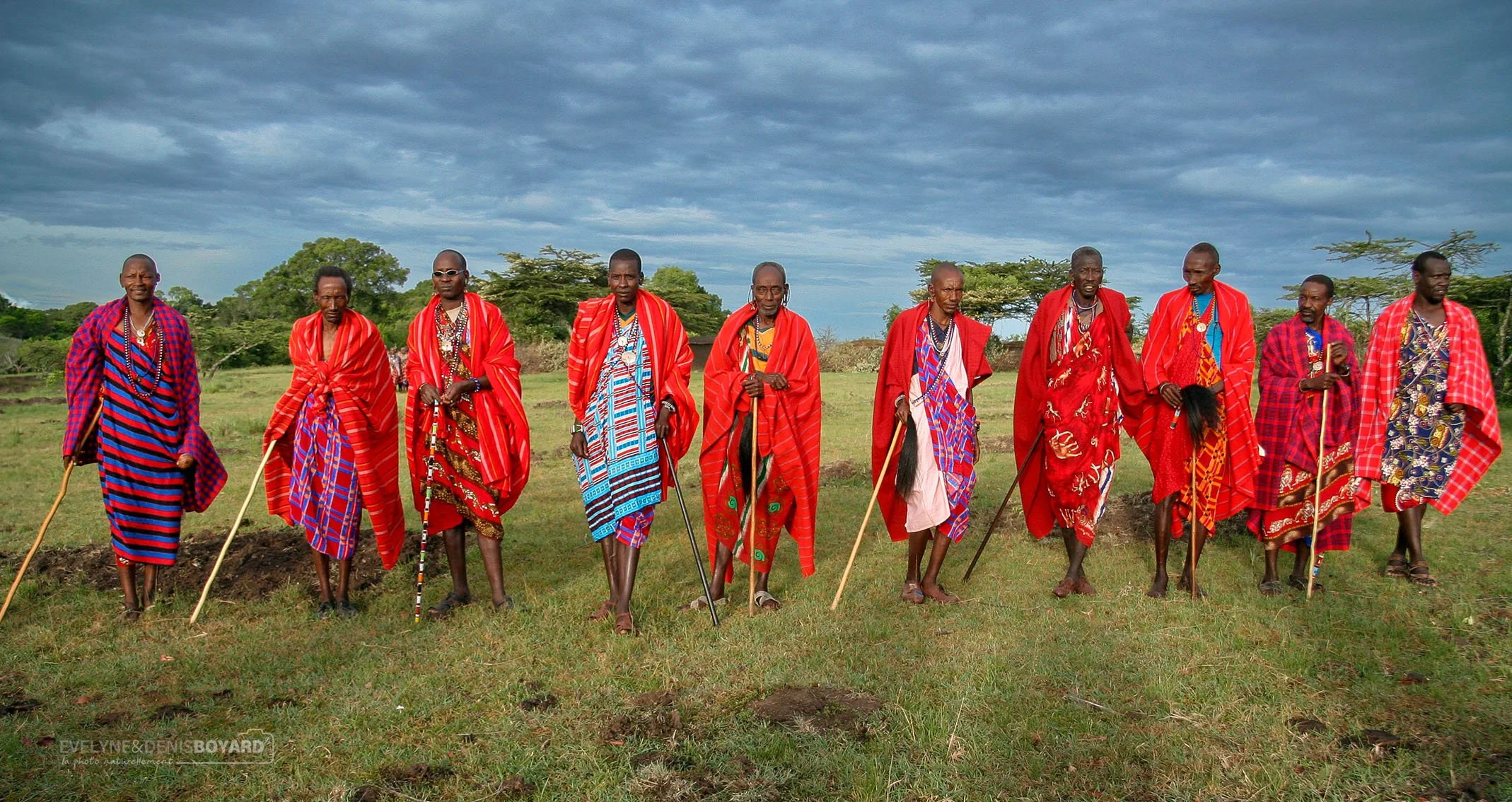 Groupe d'hommes massaïs, portant le shuka, le plaid rouge aux motifs souvent écossais.