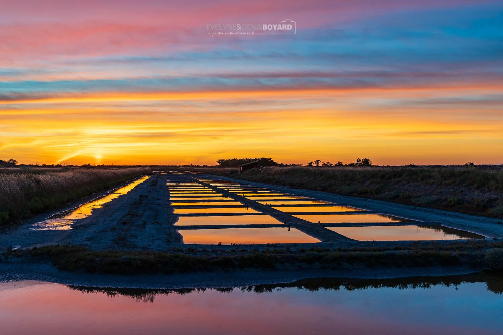 Un coucher de soleil, haut en couleurs sur les marais salants de l'île de Ré (Charente-Maritime).