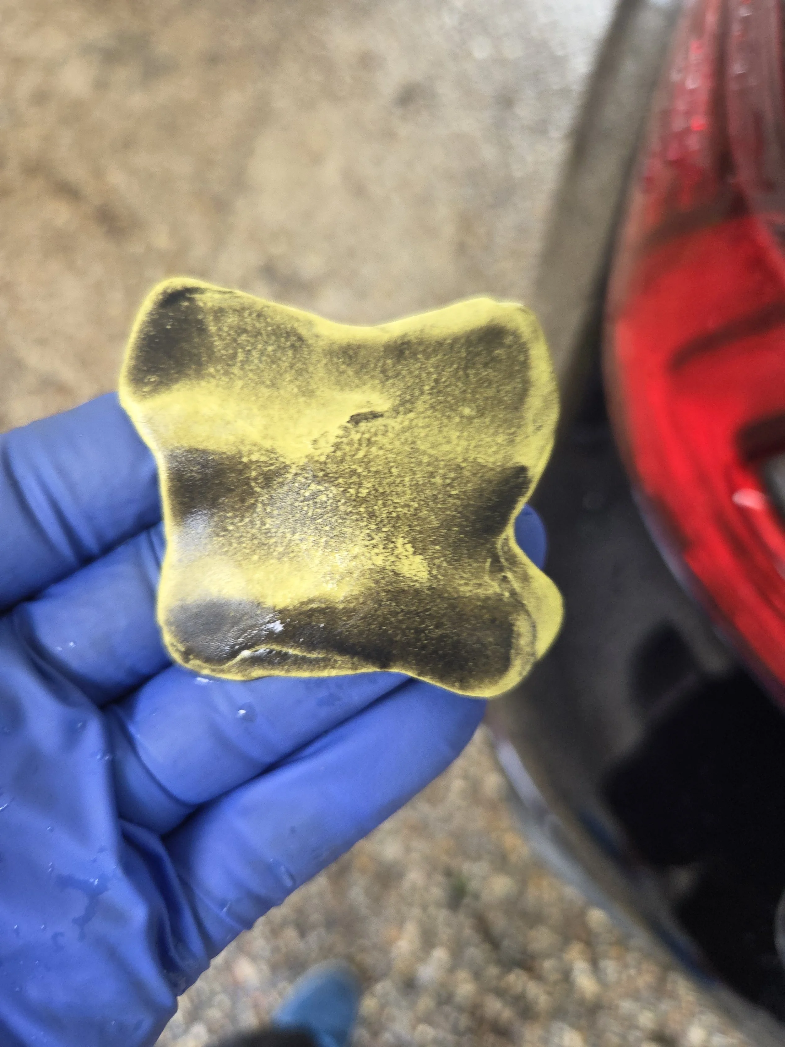 Close-up image of clay bar after decontamination of blue Lexus.