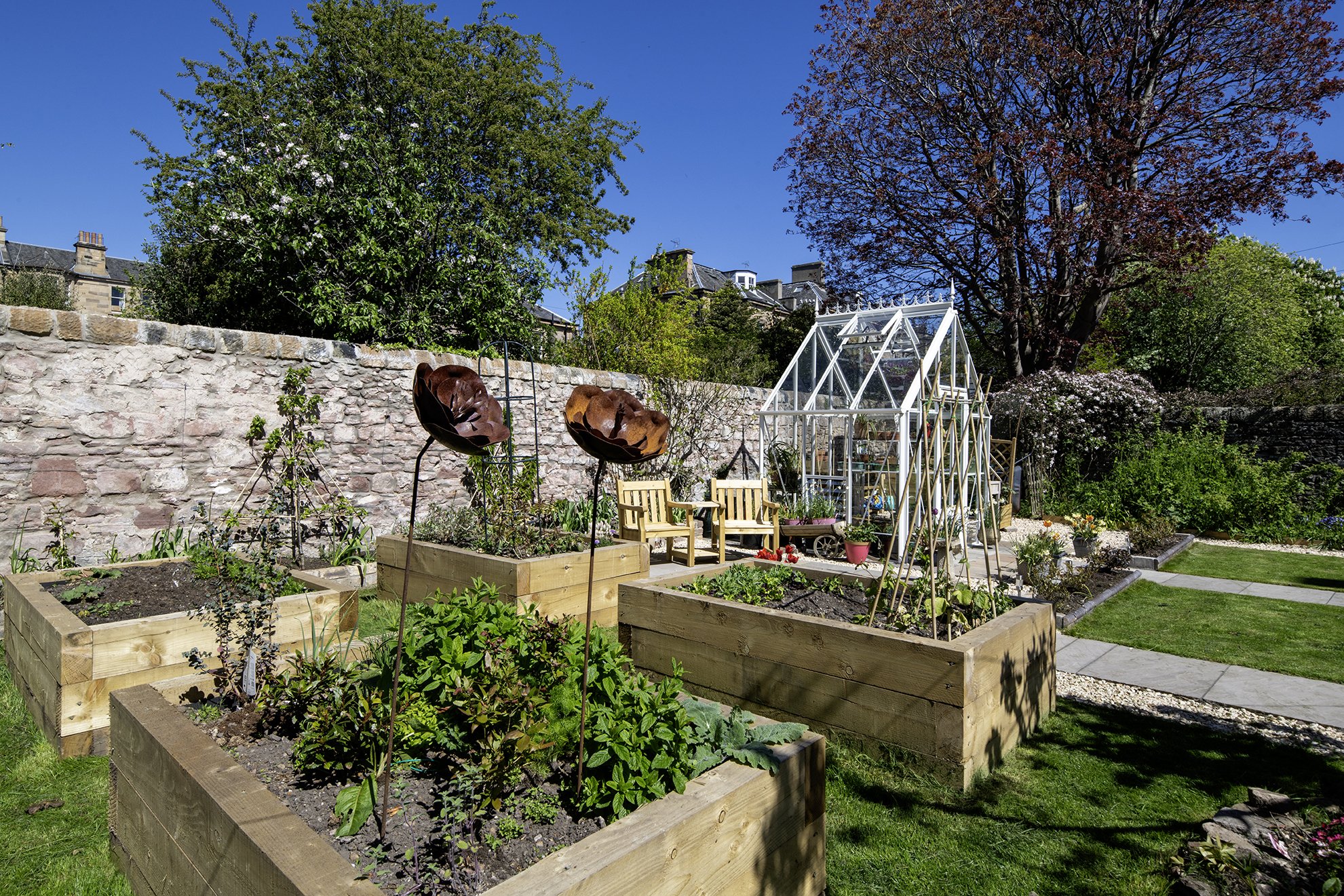 A view over raised beds to a heritage greenhouse in this beautifully designed kitchen garden.