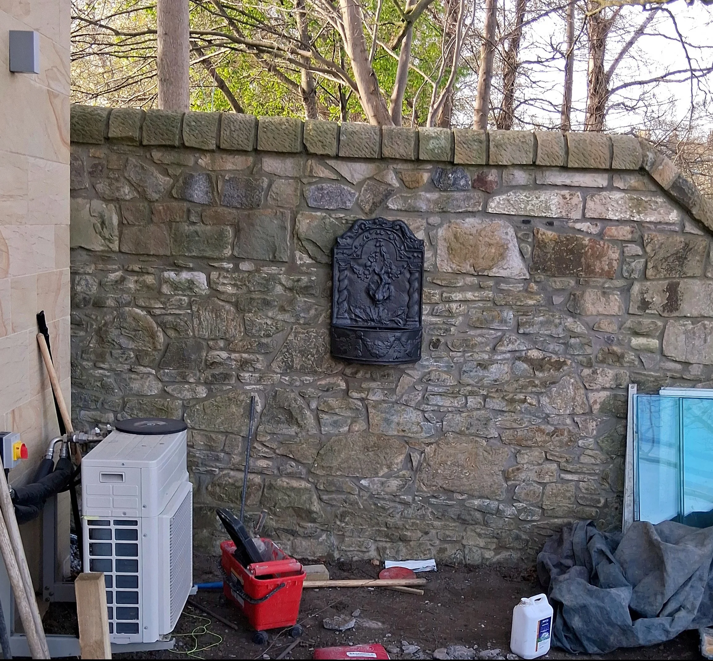 Wall fountain attached to a stone wall.